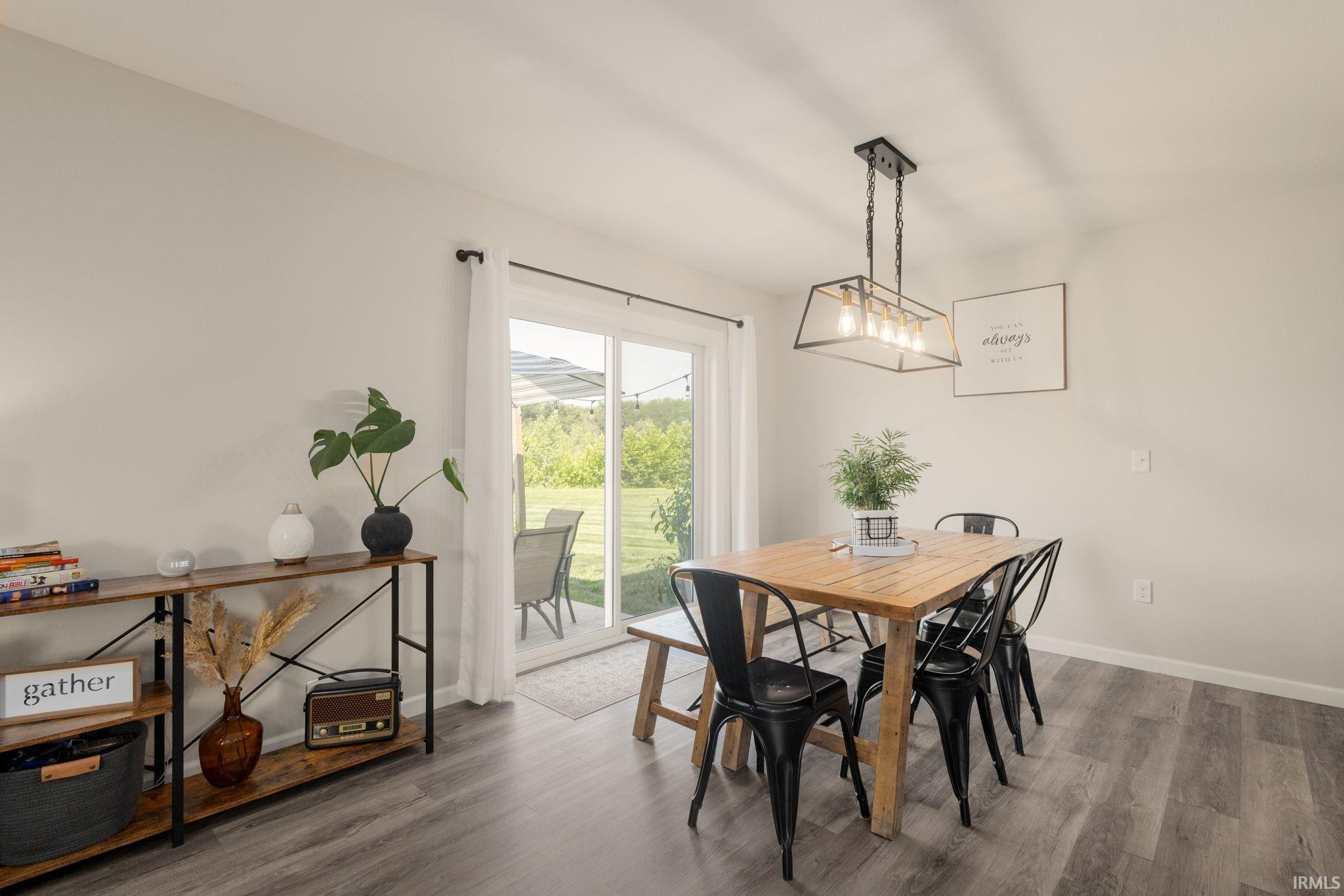 Dining area featuring wood-finish flooring and a contemporary linear chandelier