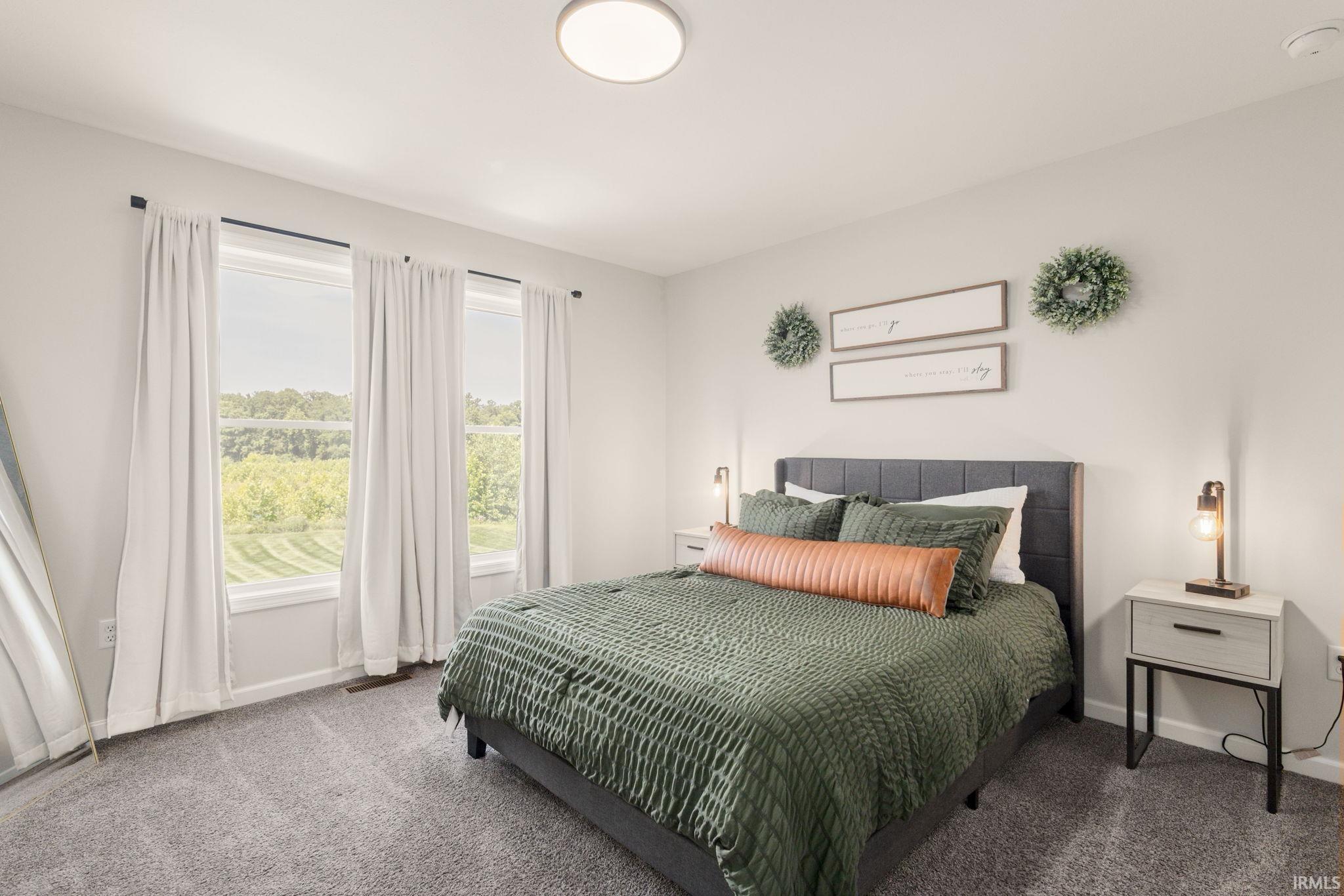 Spacious room featuring multiple windows with outdoor scenery, neutral wall tones, and carpet flooring