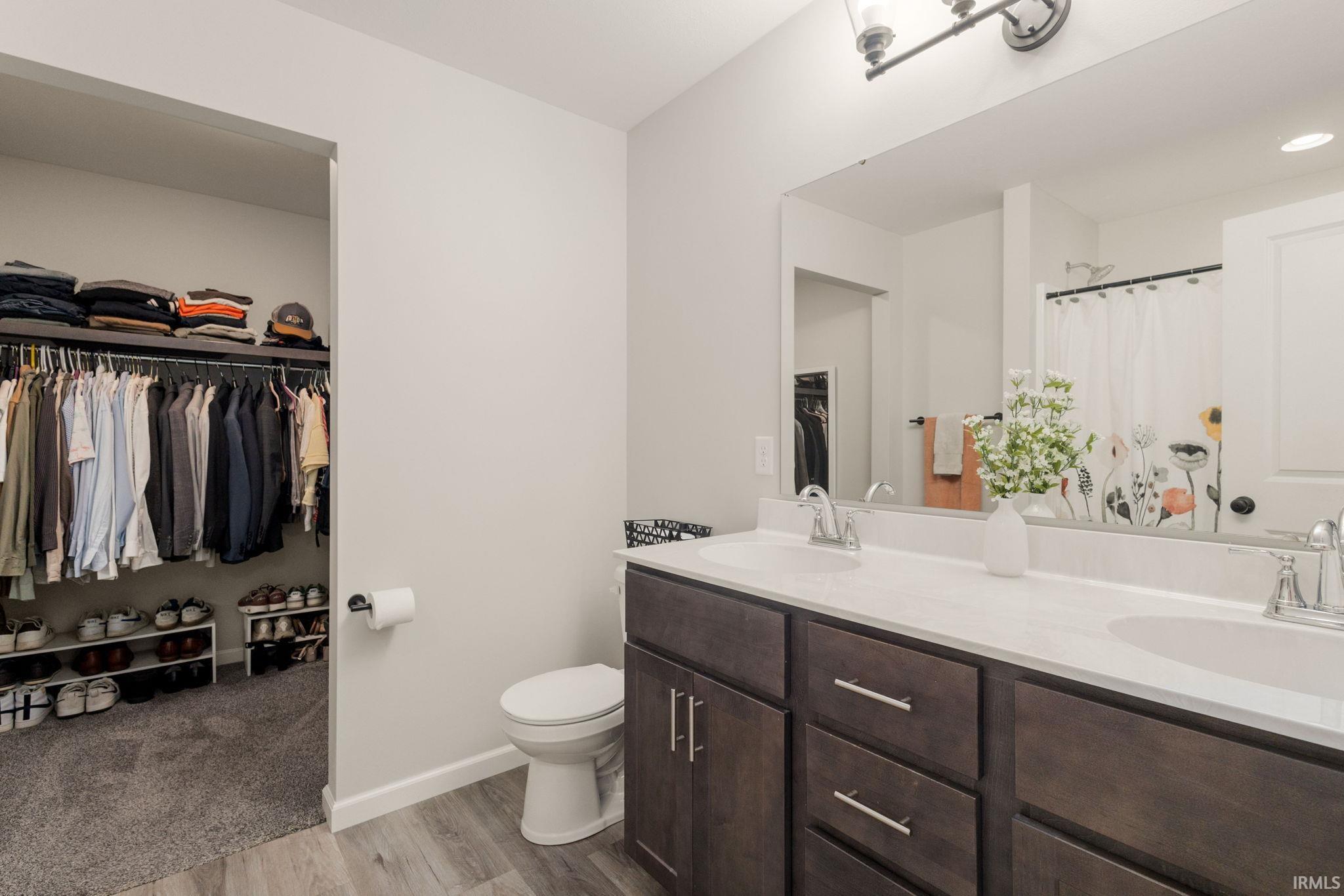 Bathroom featuring a dual-sink vanity with dark wood cabinetry and light-colored countertops