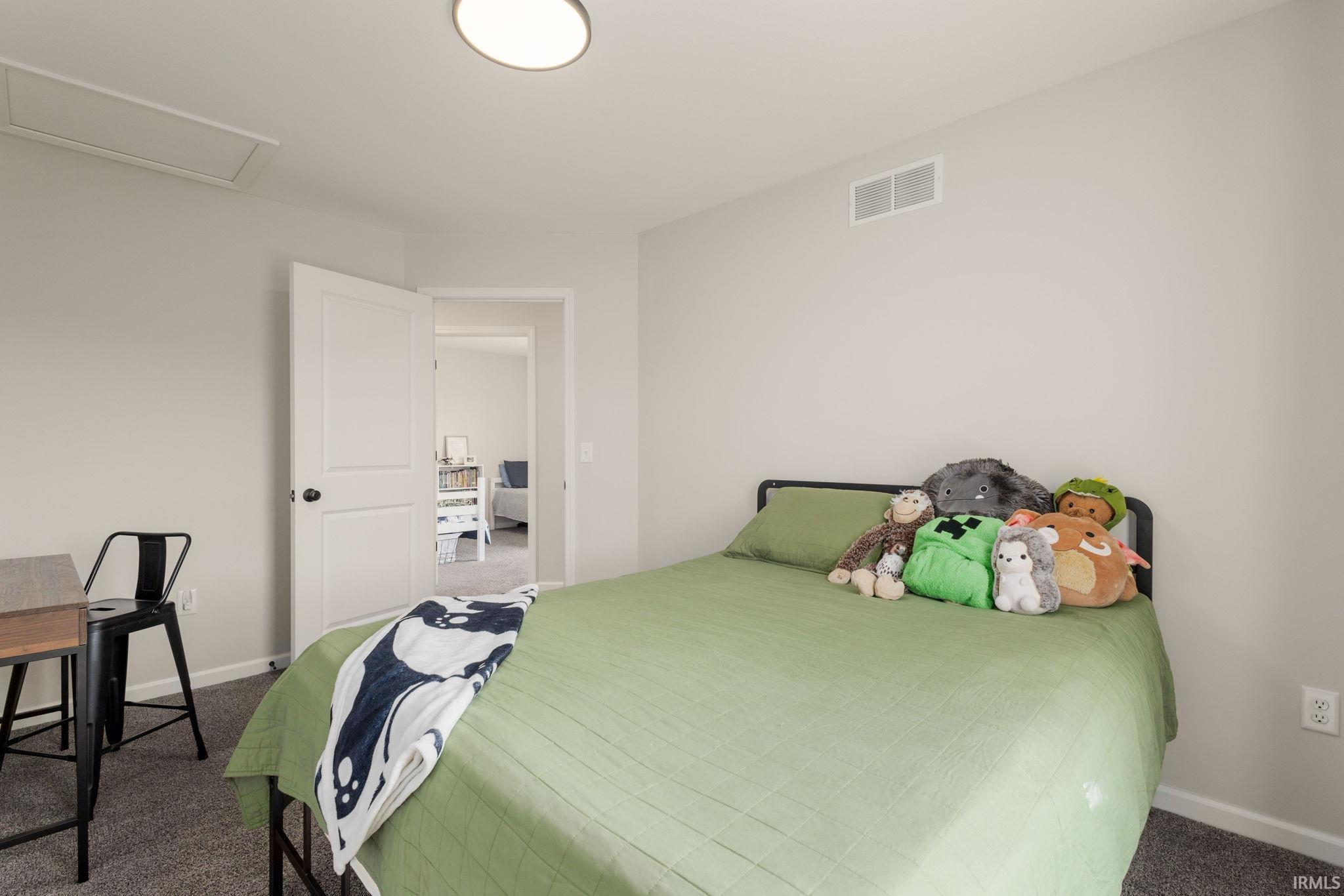 Bedroom featuring neutral wall colors, carpet flooring, a flush-mount ceiling light, and white trim