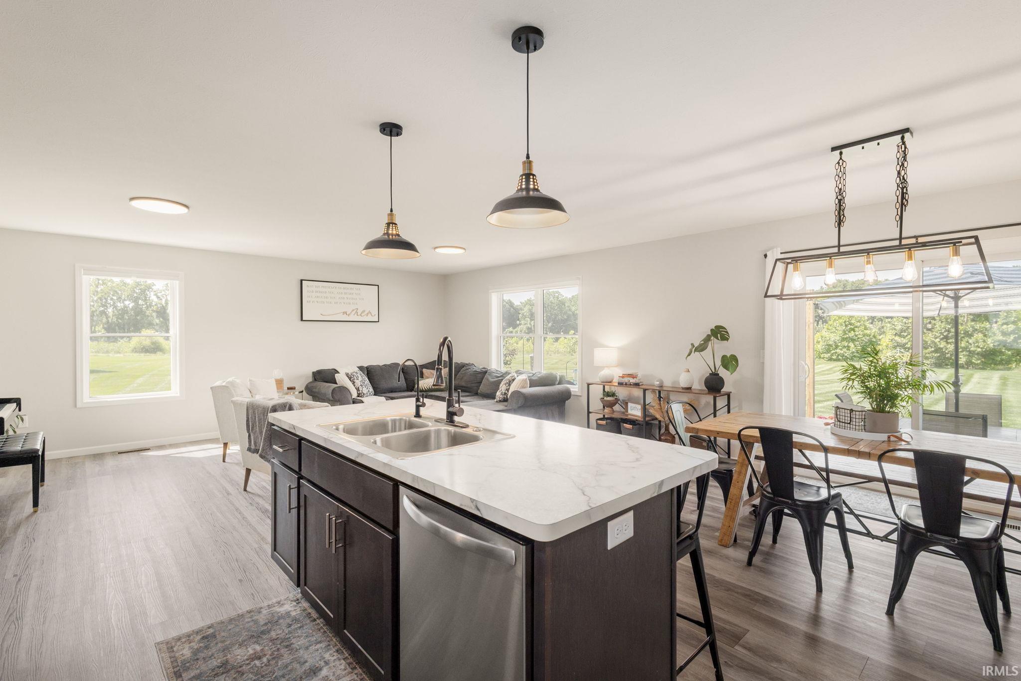 Central kitchen island with a stone-finish countertop and undermount double sink