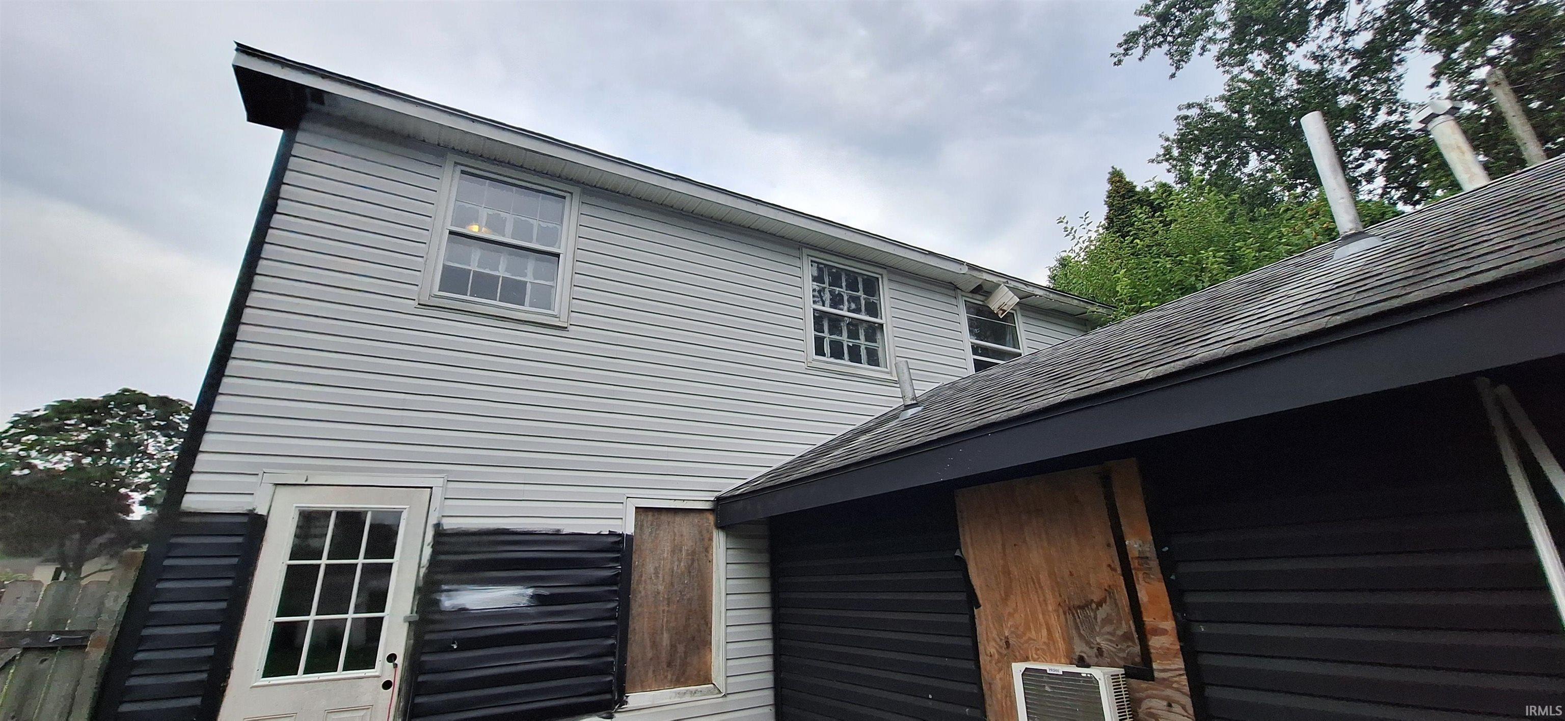 Two-story exterior with light gray siding and multiple windows