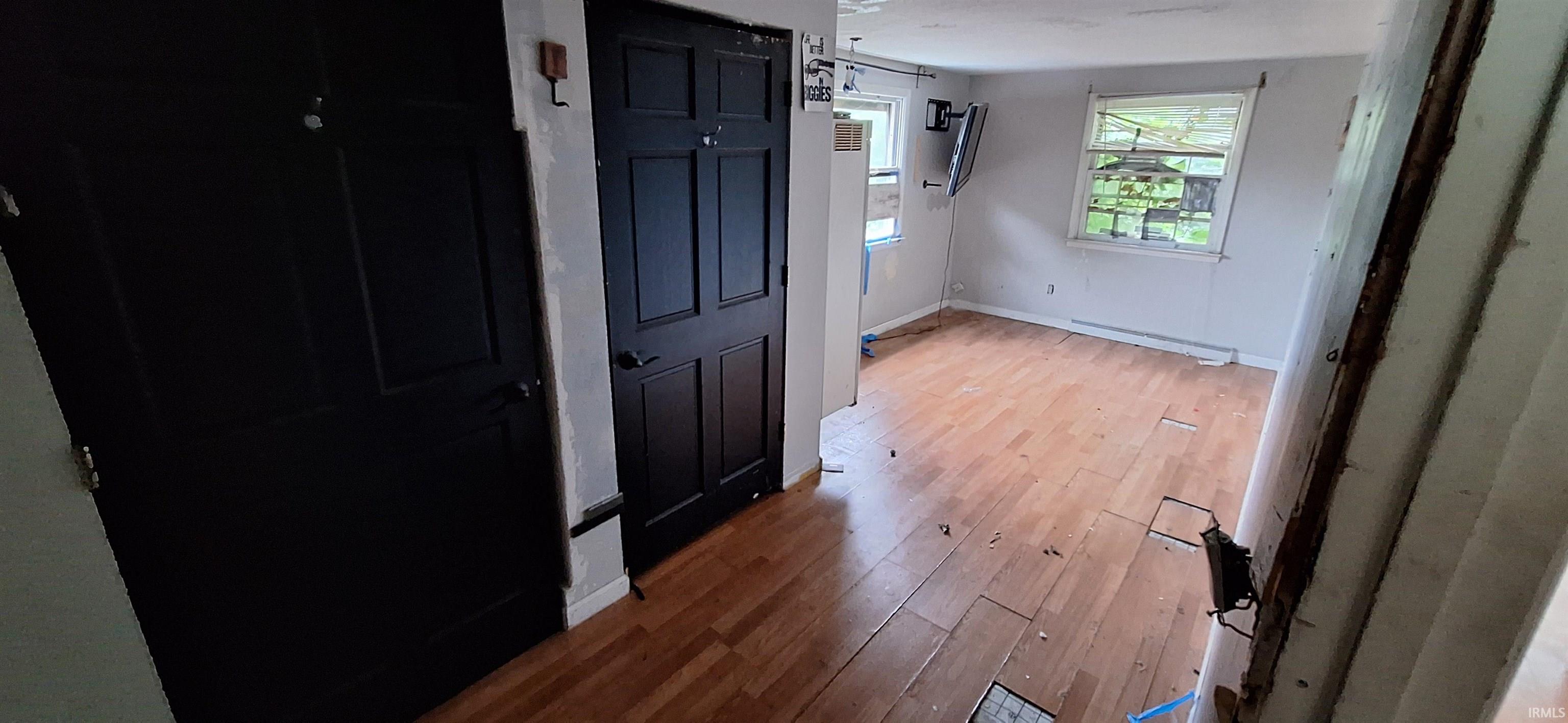 Wood-finish flooring throughout, complemented by light-colored walls and multiple windows