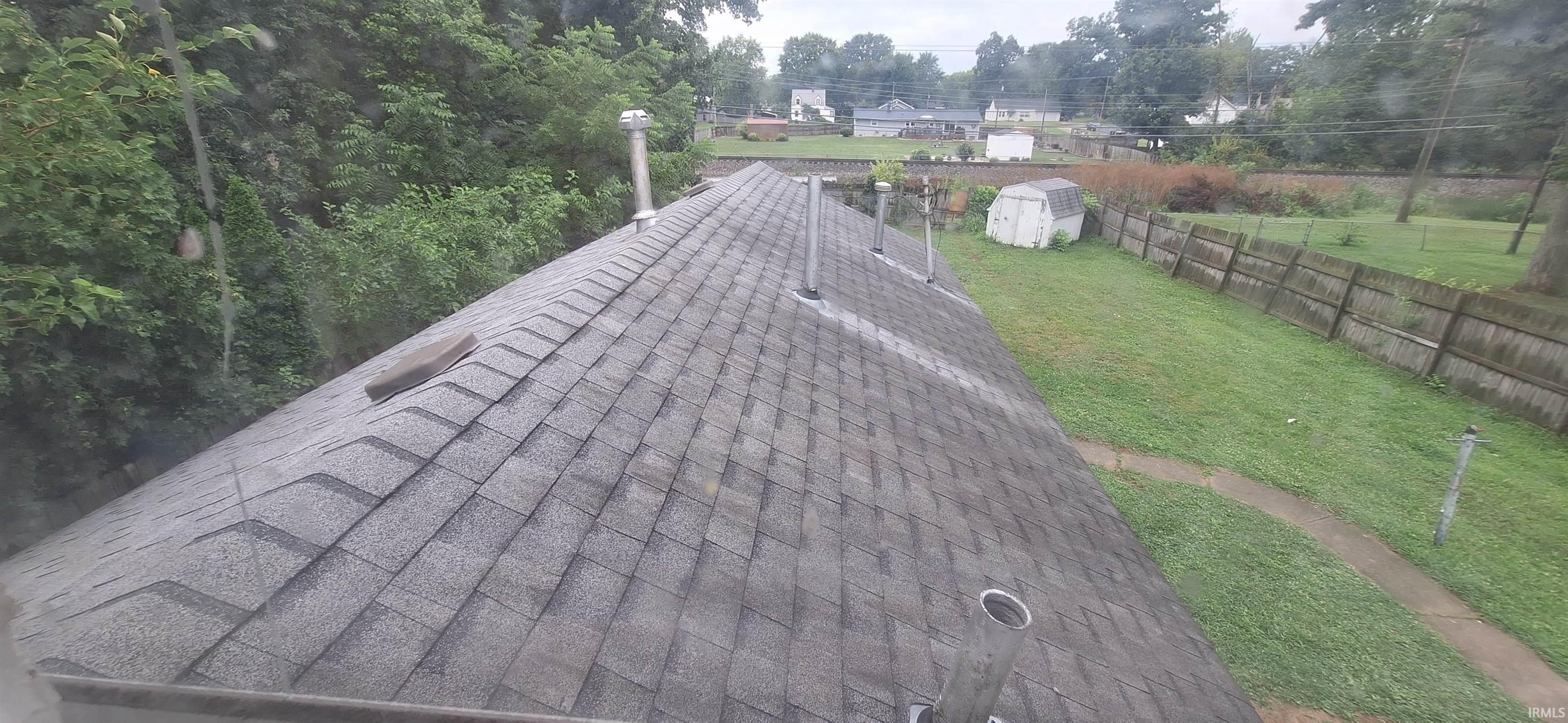 Gable roof with asphalt shingles and multiple vents, featuring a skylight