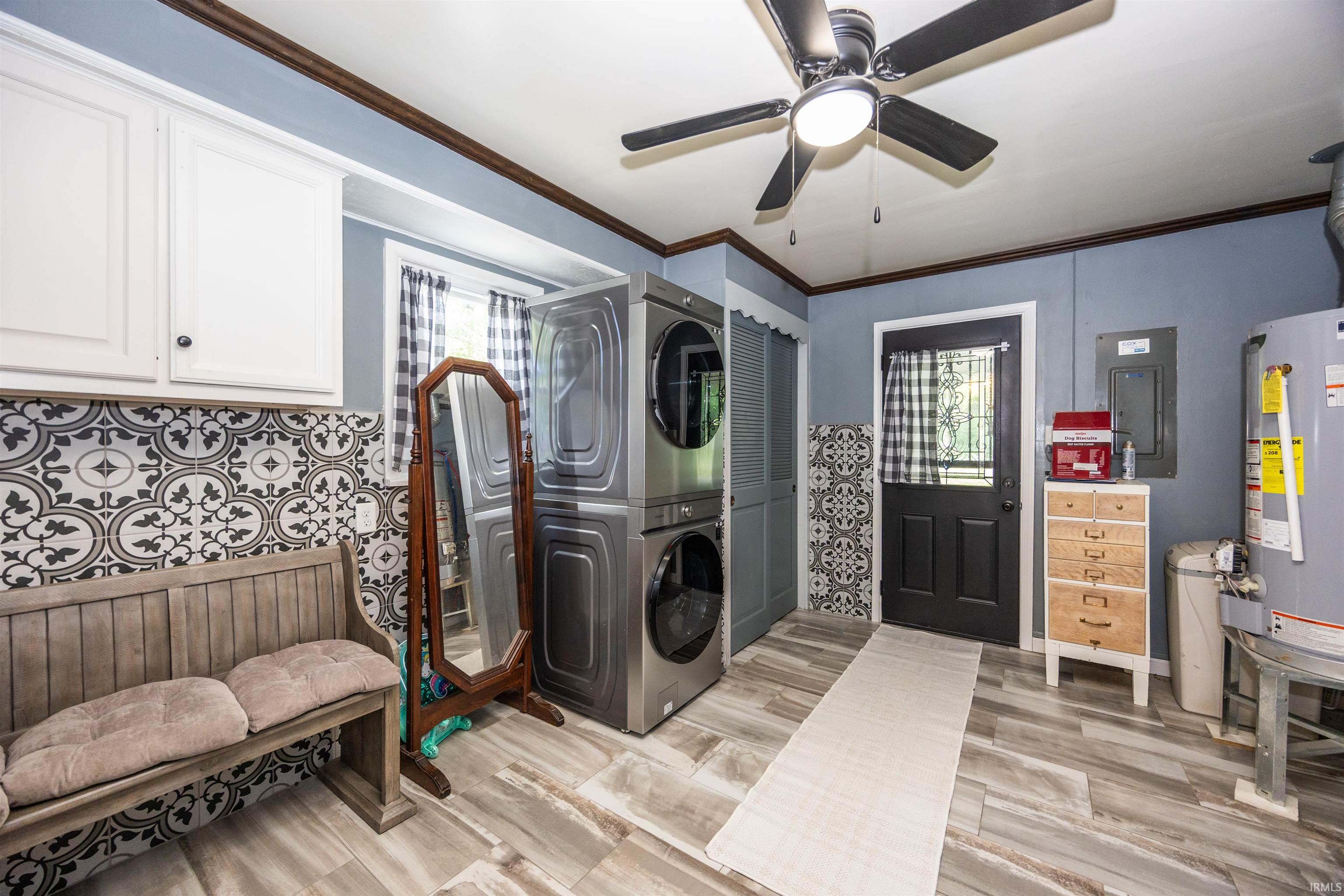 Laundry room featuring wood-finish tile flooring, patterned wall tiles, and white upper cabinetry