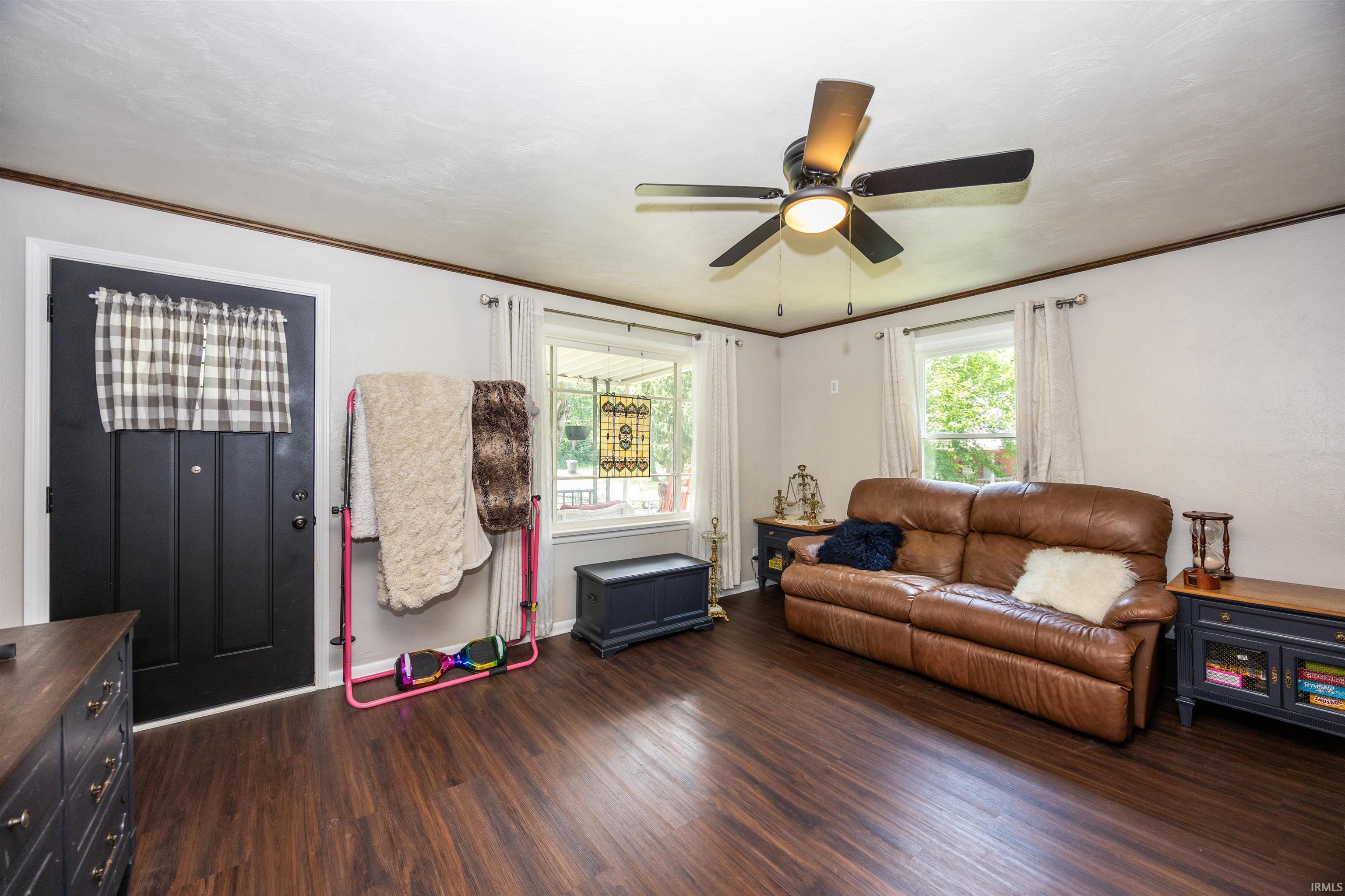 Living space featuring wood-finish flooring, white walls, and dark trim