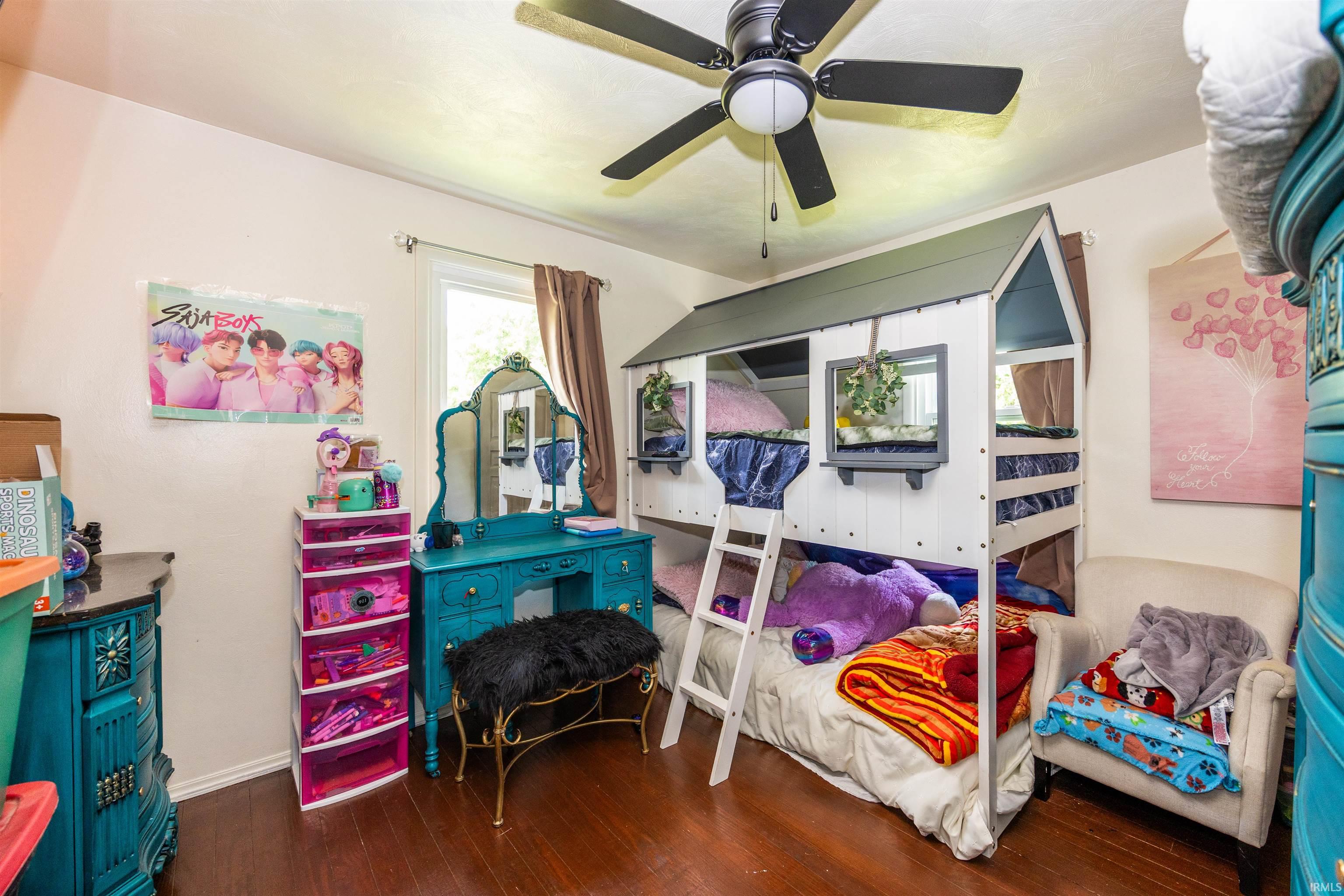 Bedroom featuring wood-finish flooring, a ceiling fan with integrated lighting, and a window with natural light