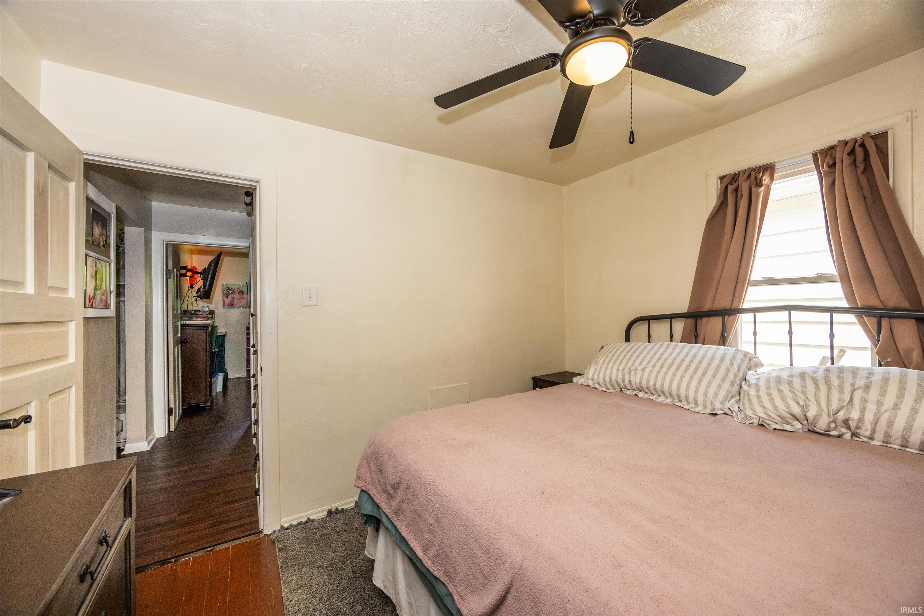Room featuring a ceiling fan with integrated lighting, a window with natural light, and light-toned walls