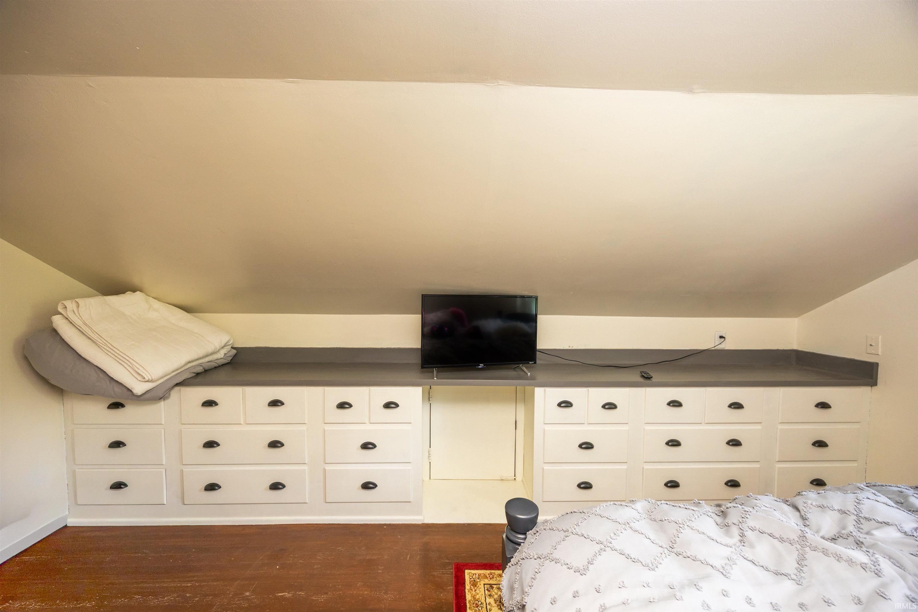 Custom built-in white cabinetry featuring multiple drawers, dark hardware, and a contrasting gray countertop