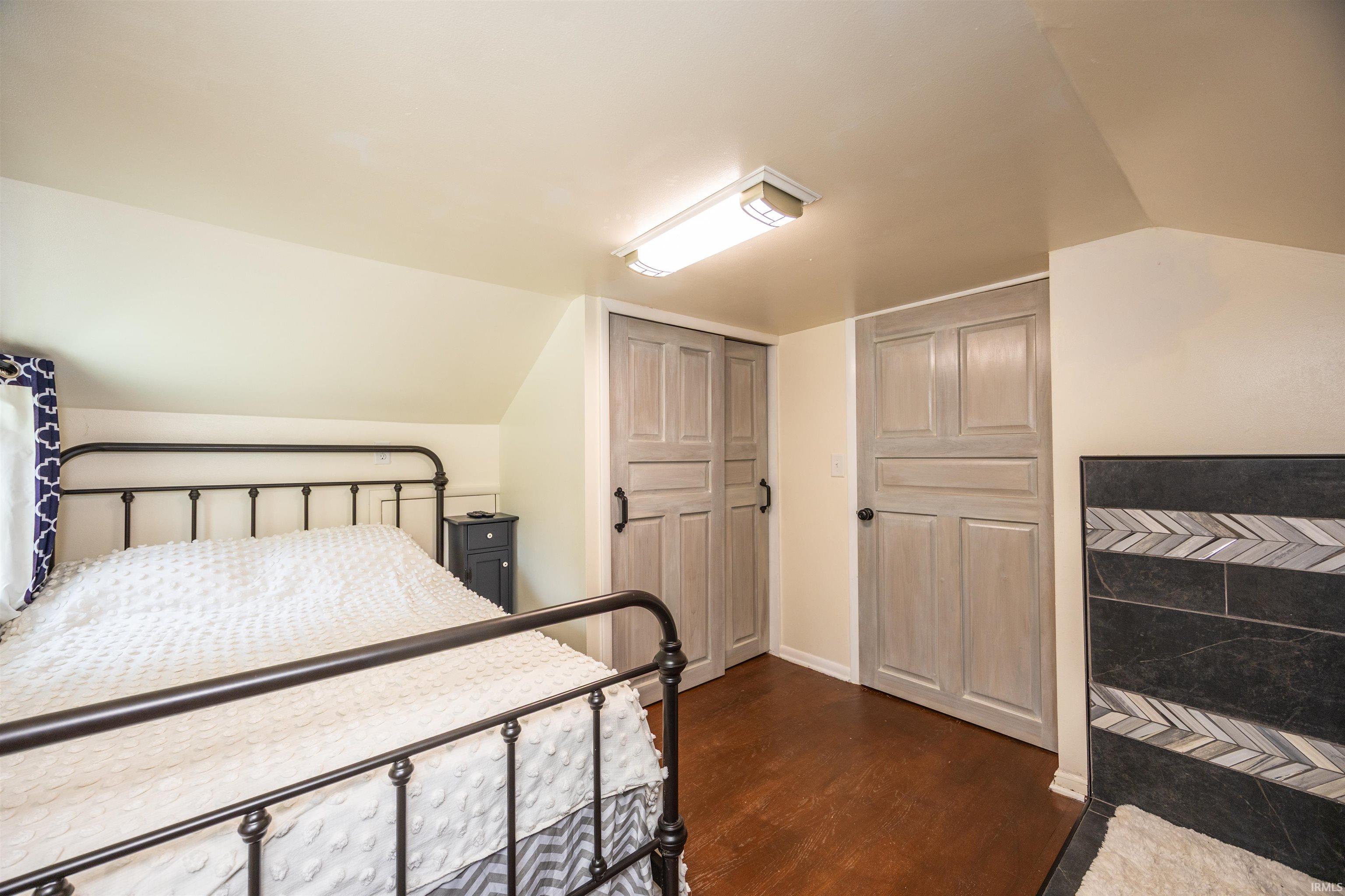 Room featuring wood-finish flooring and a sloped ceiling