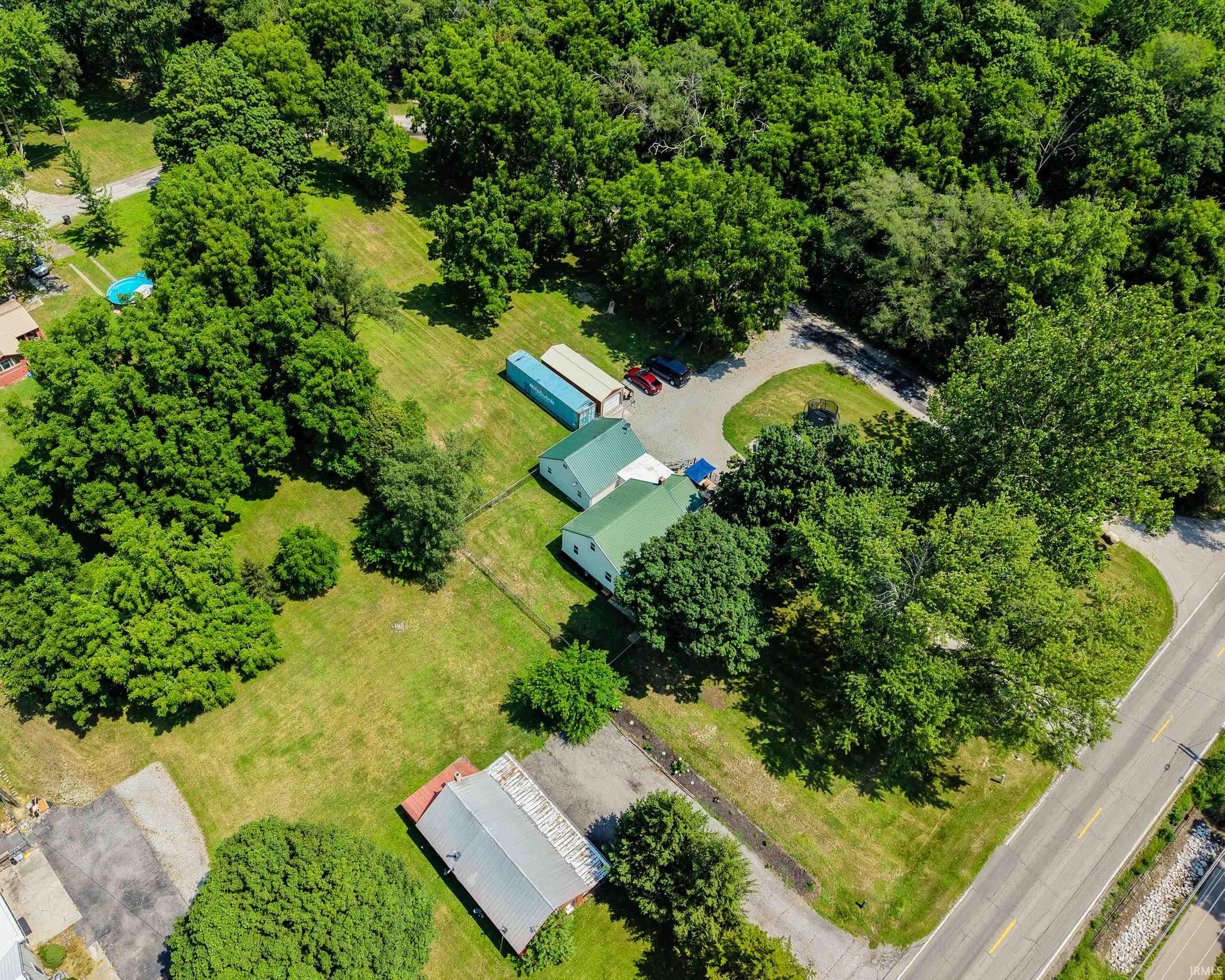 Aerial perspective showcasing multiple structures and expansive treed areas
