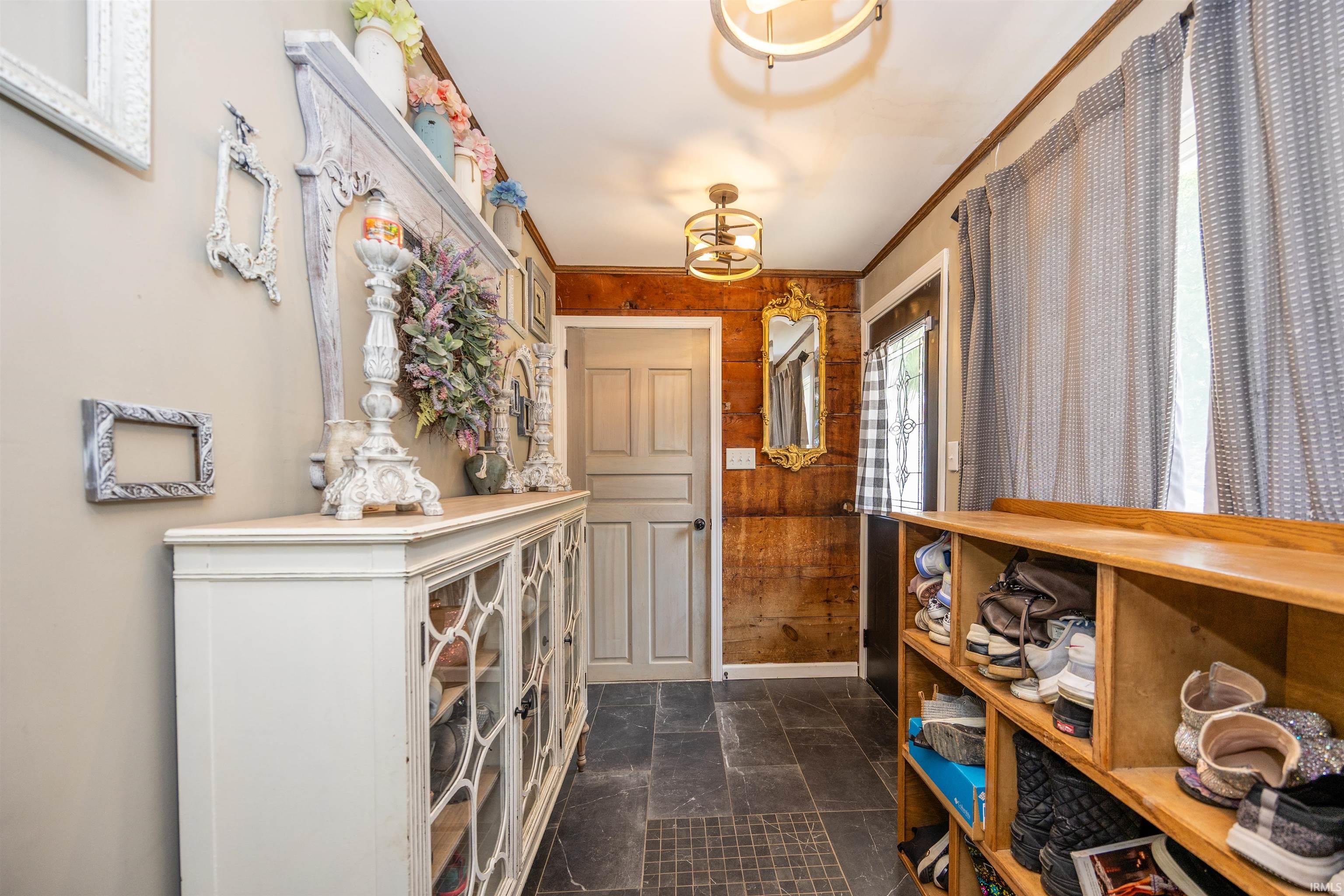 Entryway featuring black slate tile flooring and a built-in wooden shoe organizer