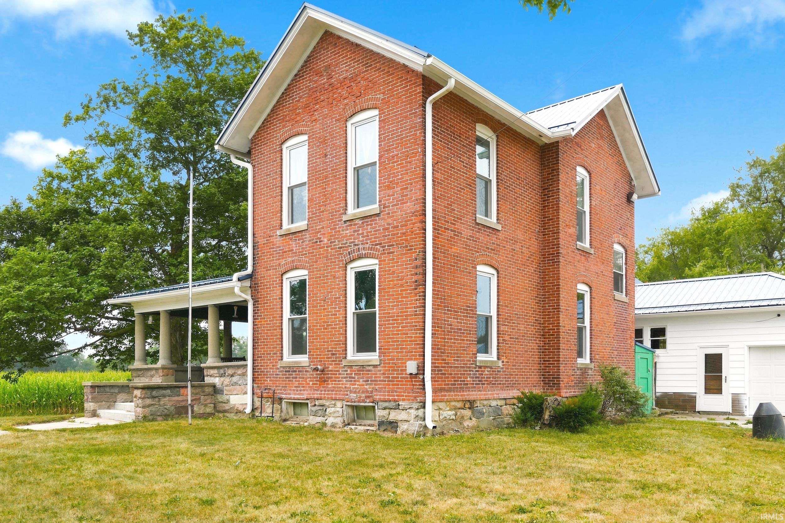 Brick exterior featuring a stone foundation and white trim
