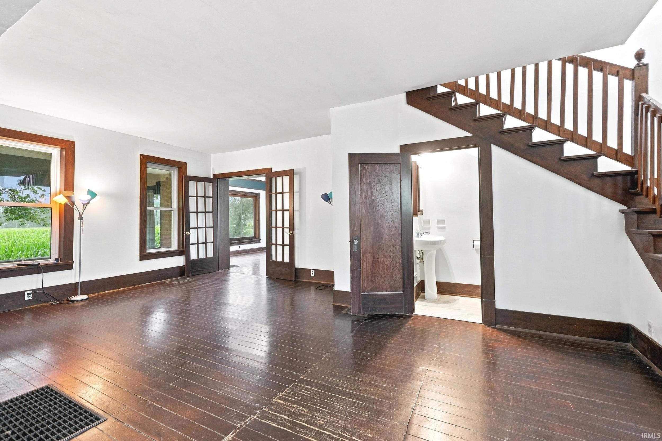 Hardwood flooring throughout, featuring dark wood trim and window frames