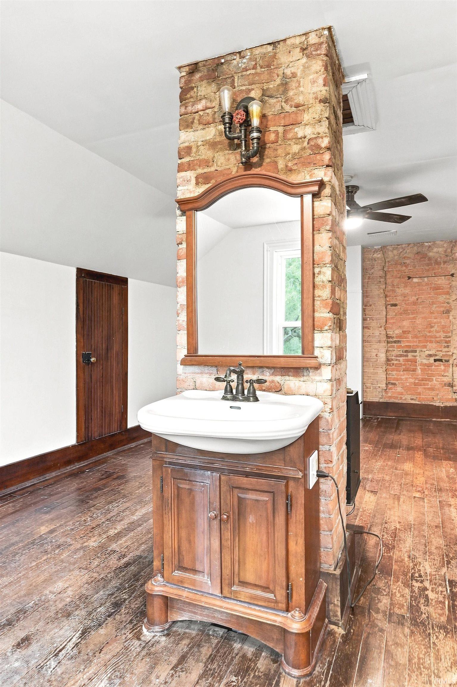 Freestanding wood vanity with an integrated sink and bronze-finish faucet