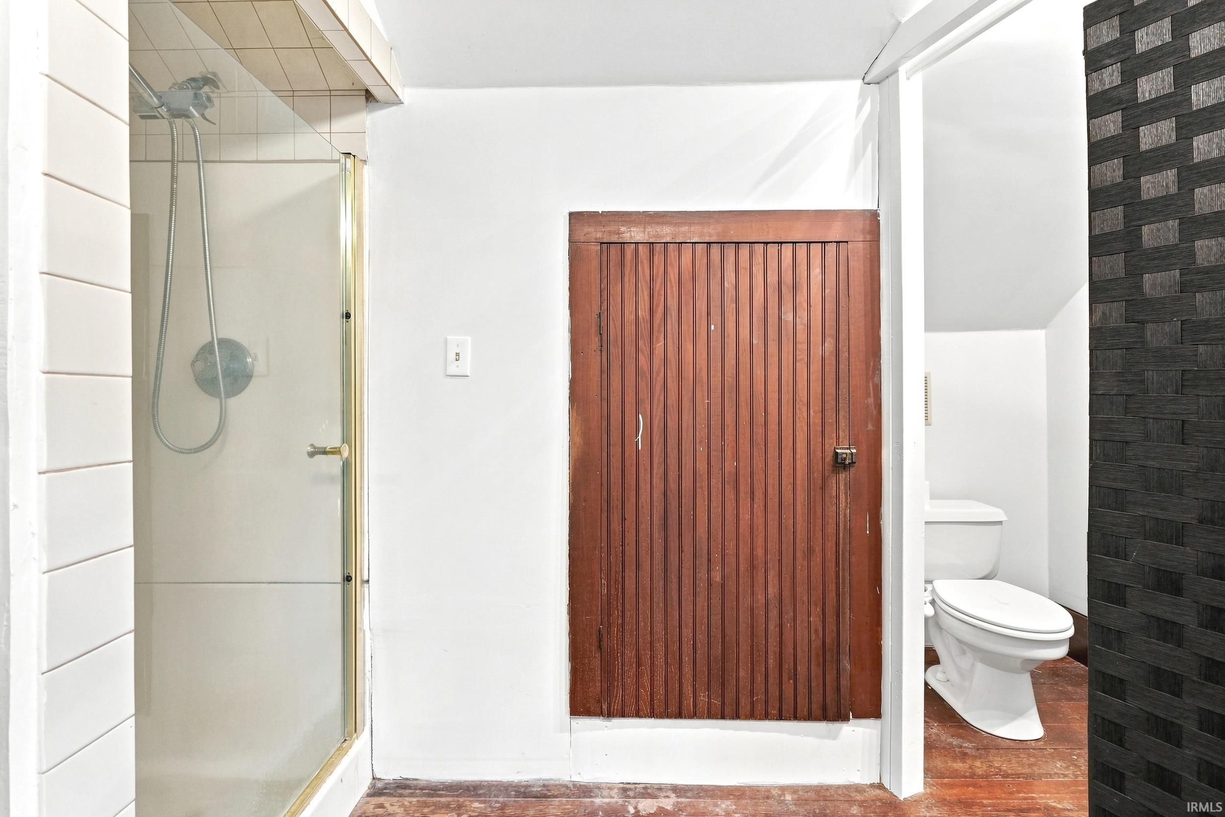 Tiled shower enclosure with a glass door and metal frame