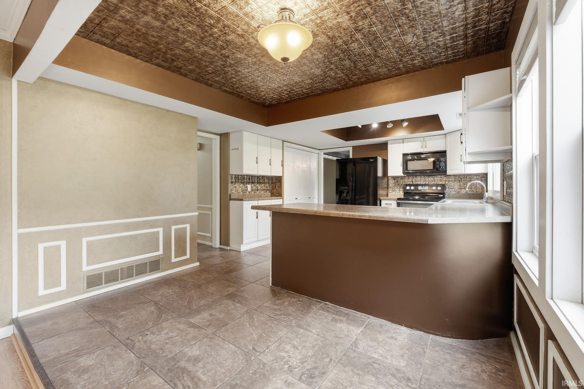Recessed ceiling with textured paneling and overhead lighting