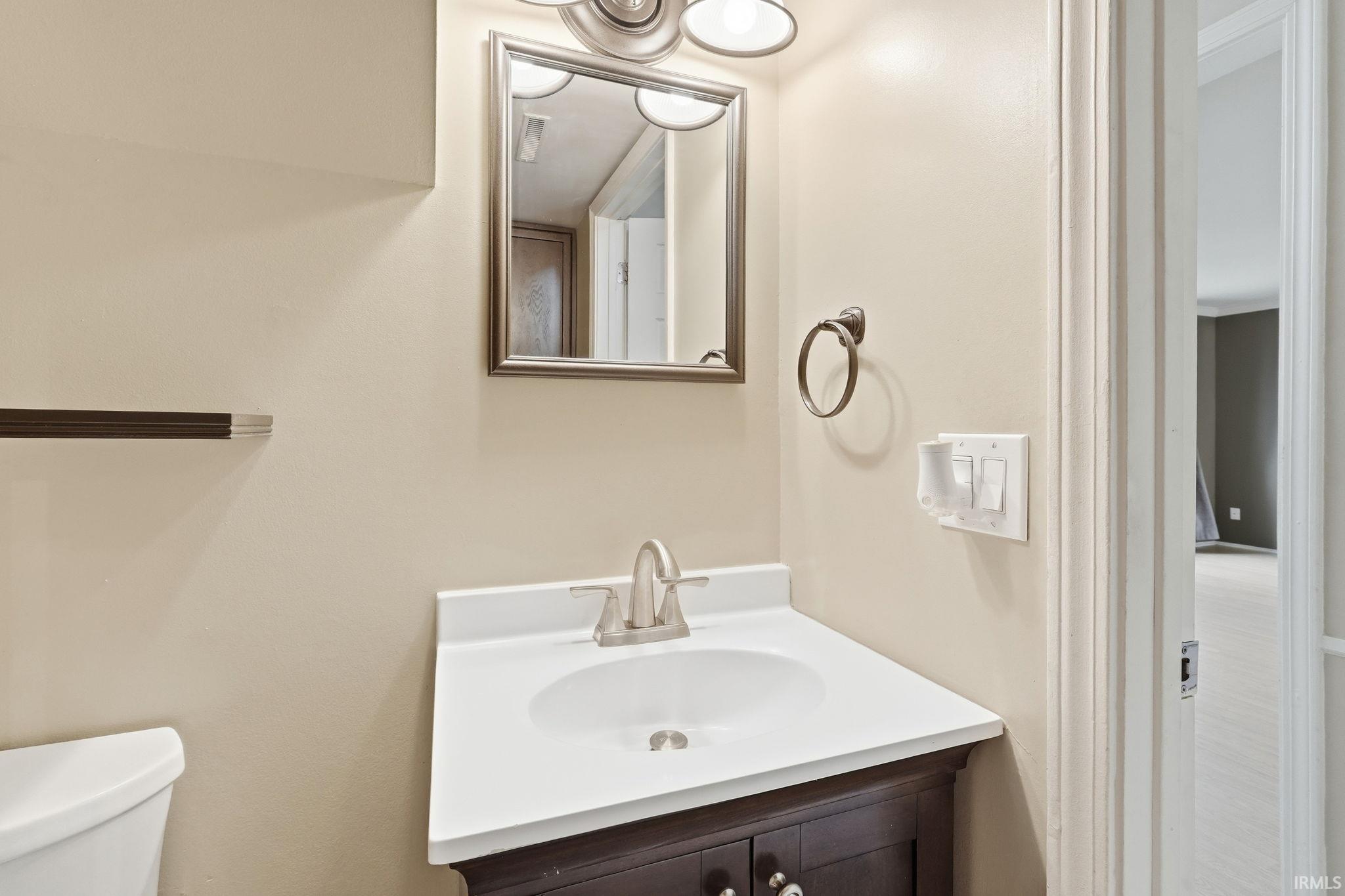 Dark wood-finish vanity with a white countertop and integrated sink