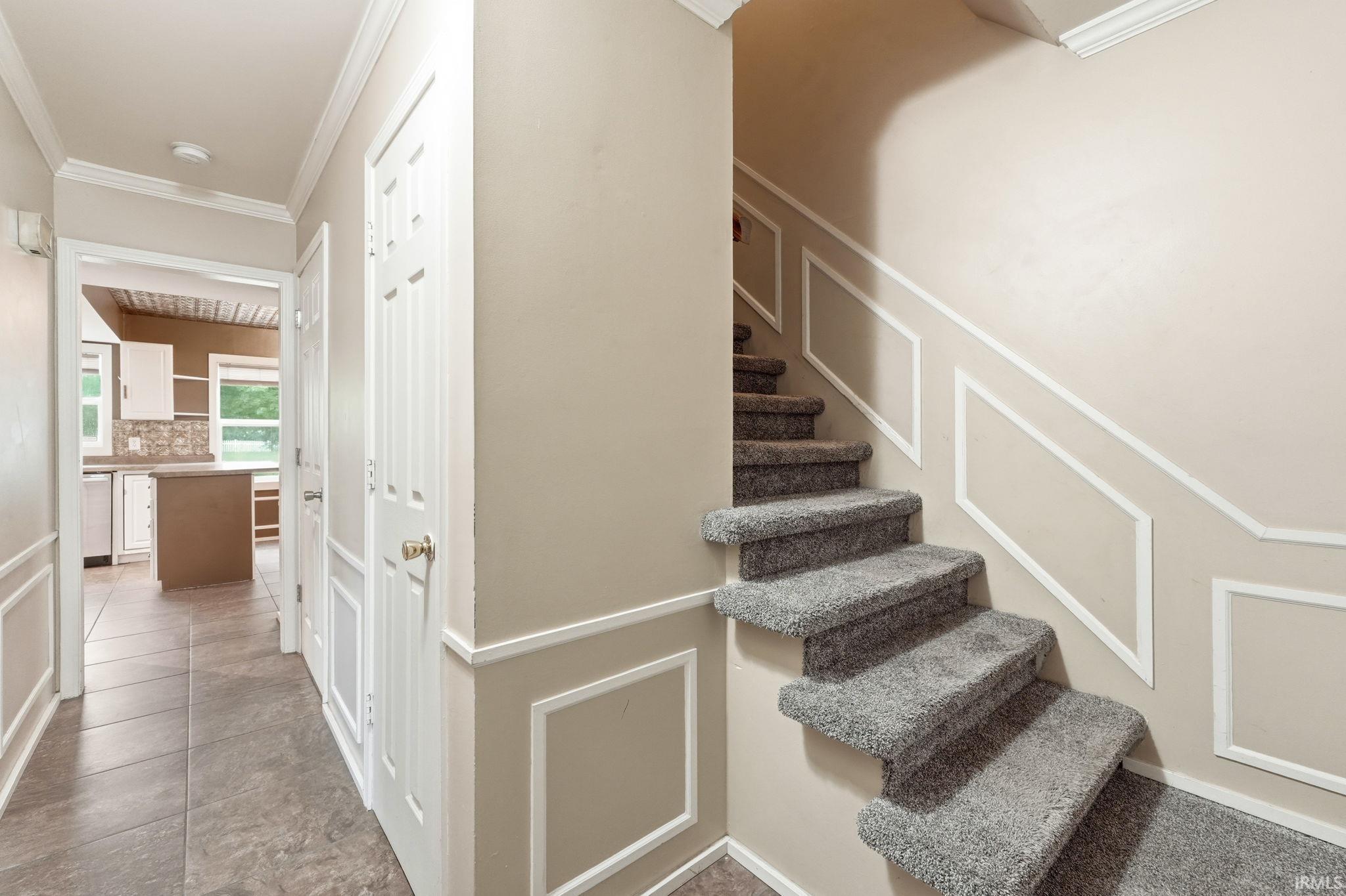 Carpeted staircase with decorative wall molding