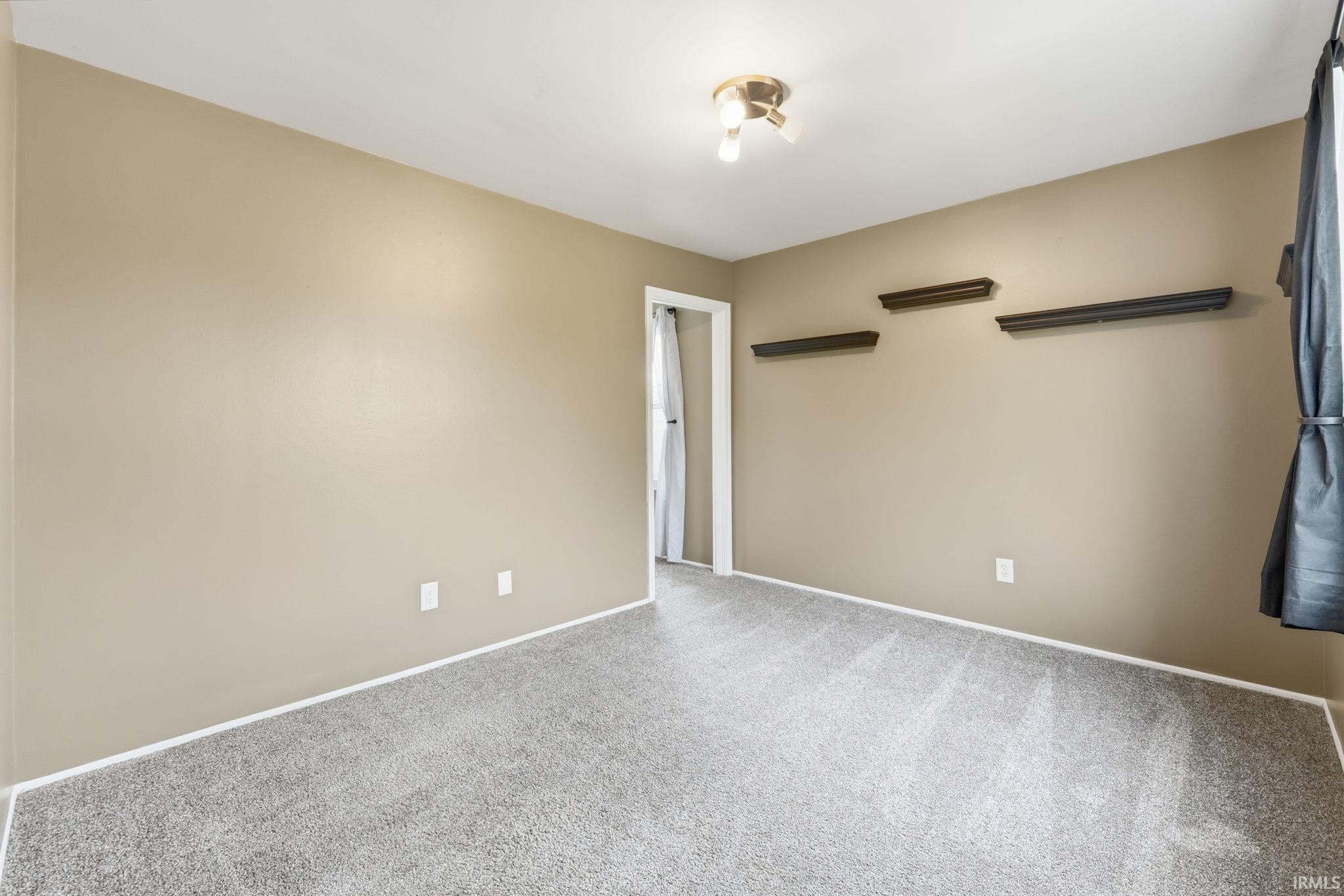 Neutral-toned walls complement the gray carpeting
