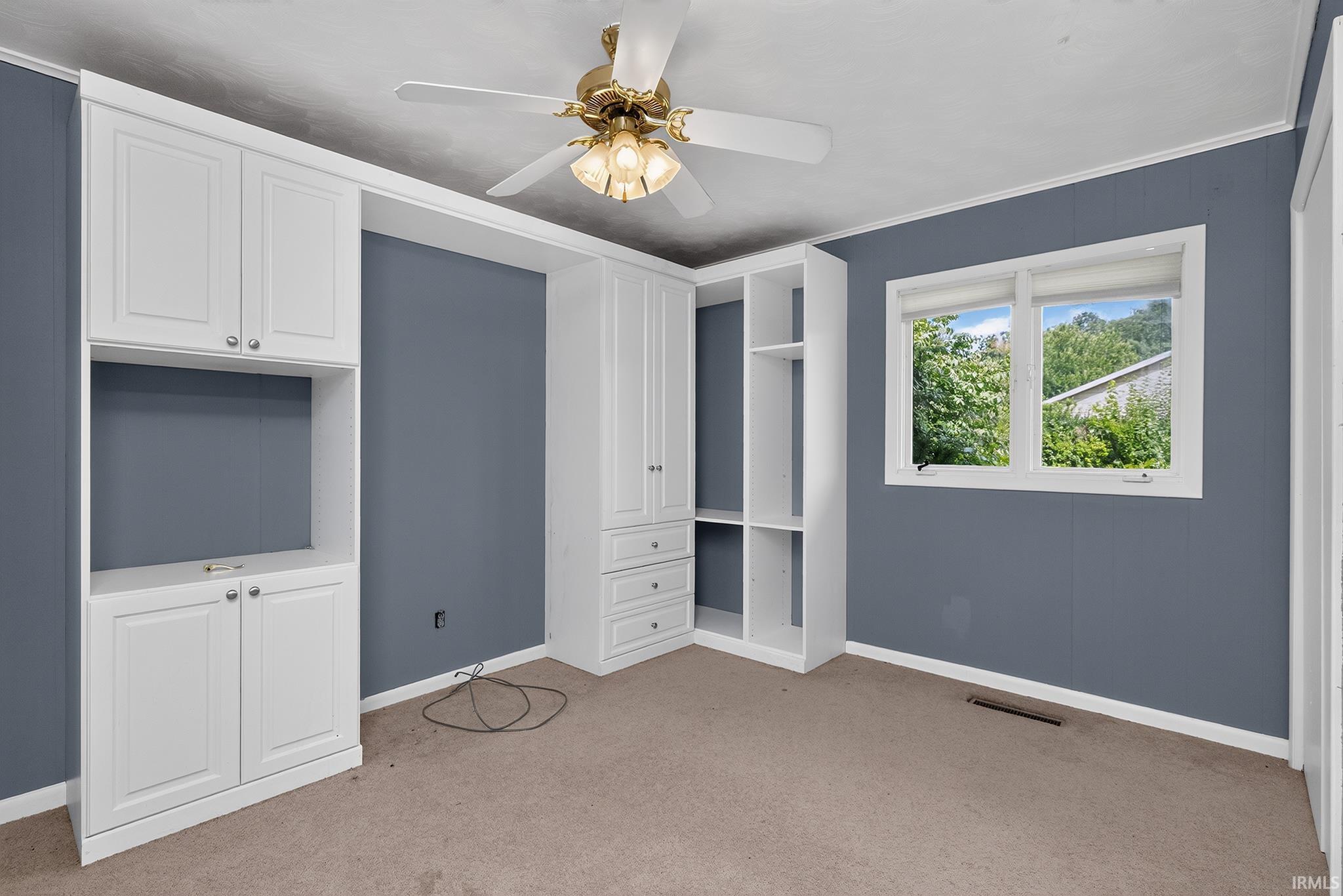 Sophisticated home office featuring built-in white cabinetry with integrated shelving and media storage, soft-close drawers, and a dedicated workspace nook
