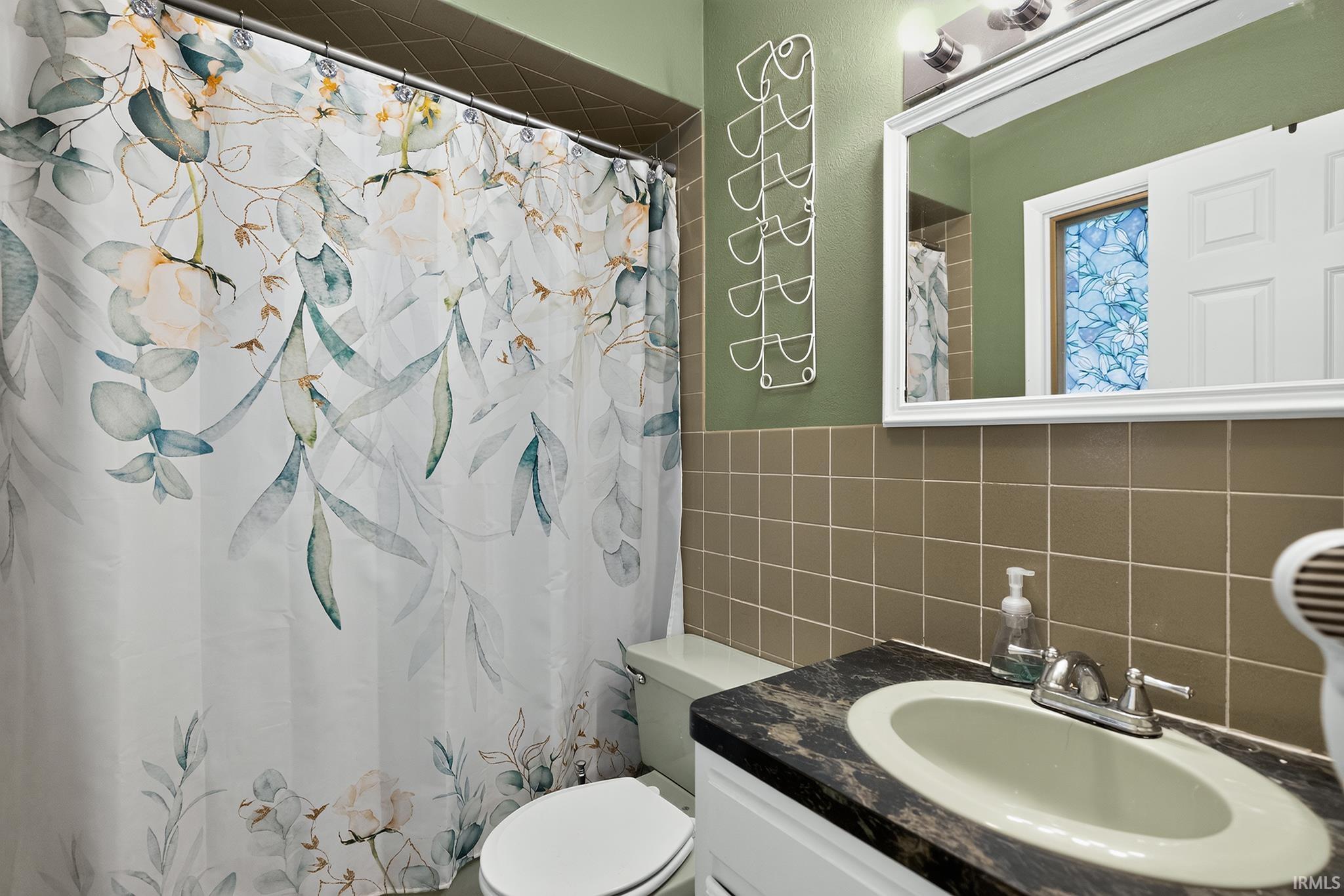 Vanity with integrated sink and chrome faucet, set against a tiled wall