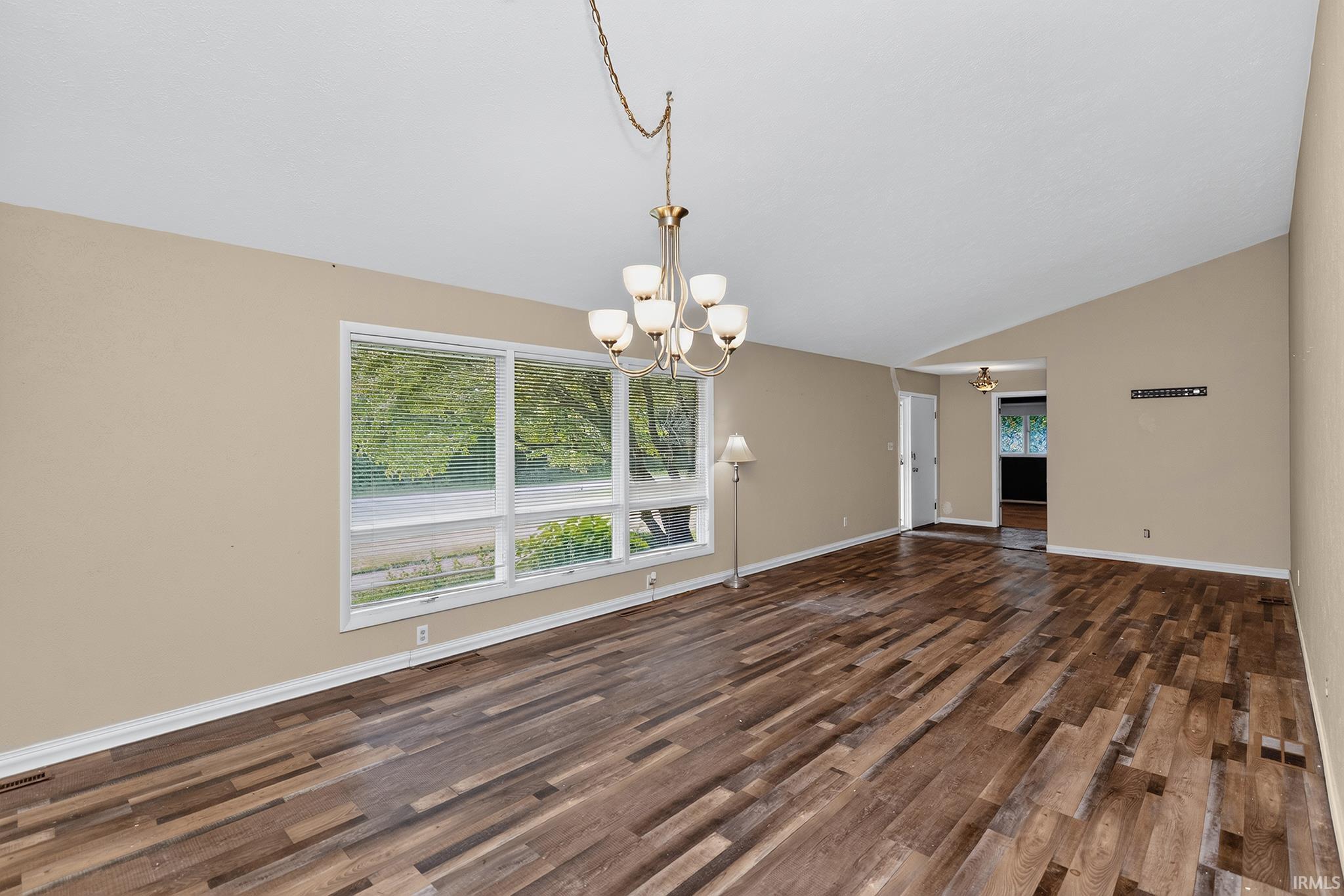 Vaulted ceilings, wood-finish flooring, and a multi-pane window