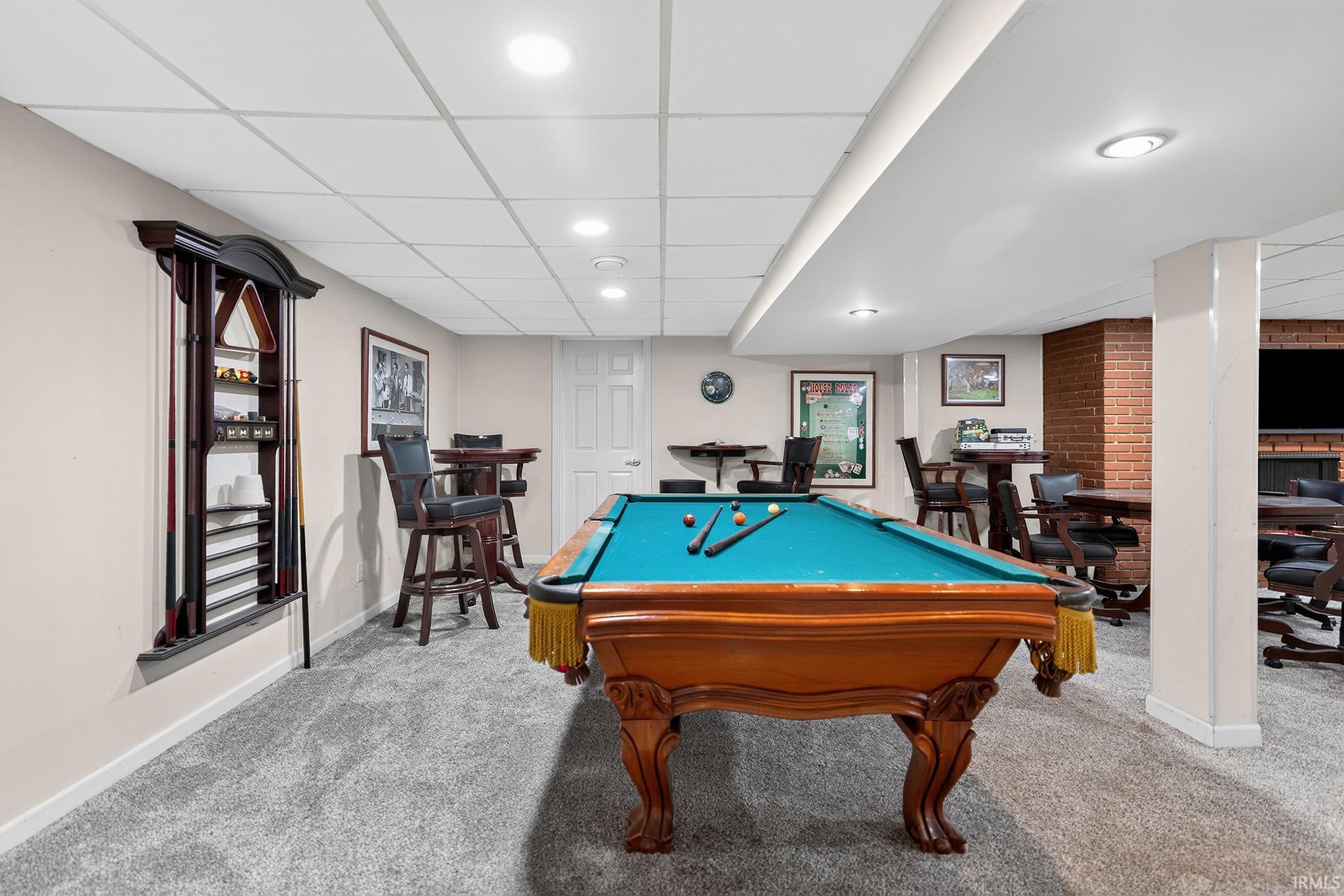Finished lower level with recessed lighting, plush carpeting, and exposed brick accent wall