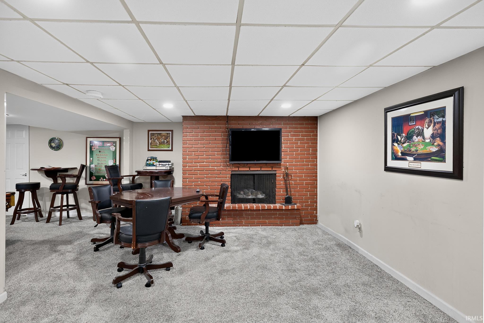 Finished lower level with a brick-clad fireplace, built-in hearth, and recessed lighting