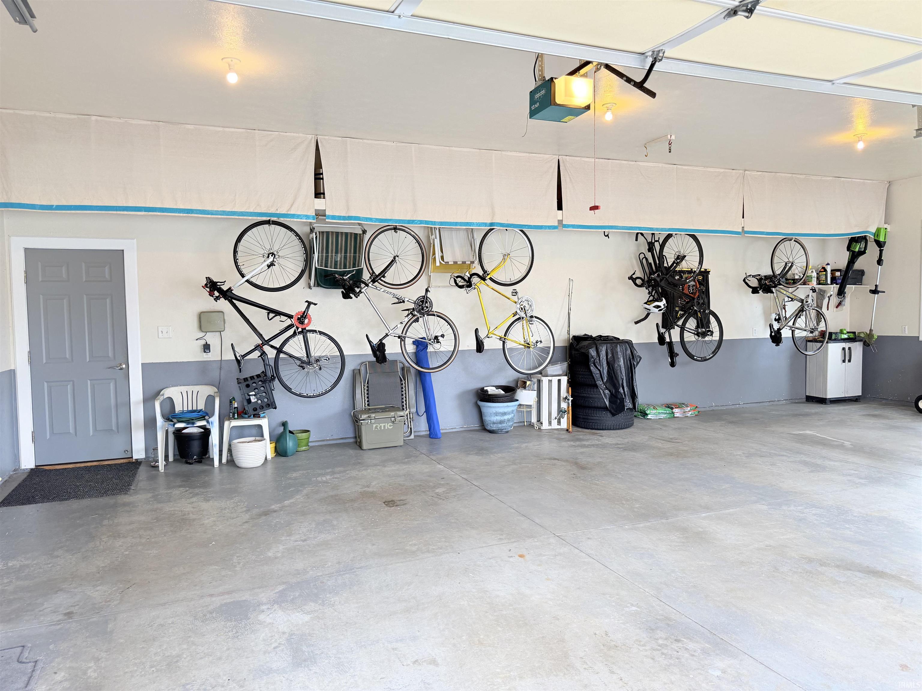 Spacious garage featuring a concrete floor, overhead lighting, and an automatic garage door opener