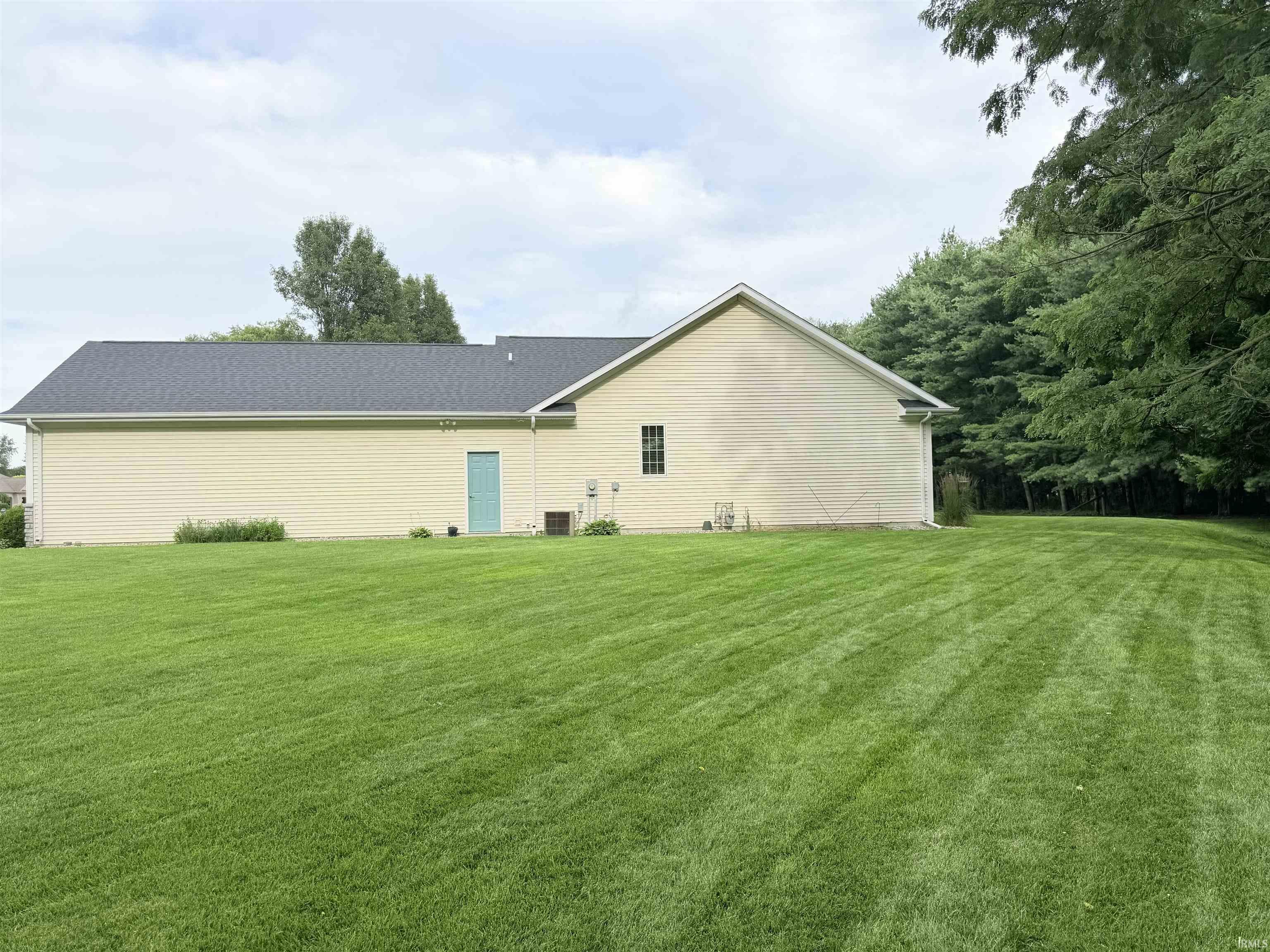 Spacious side yard featuring a large expanse of green lawn