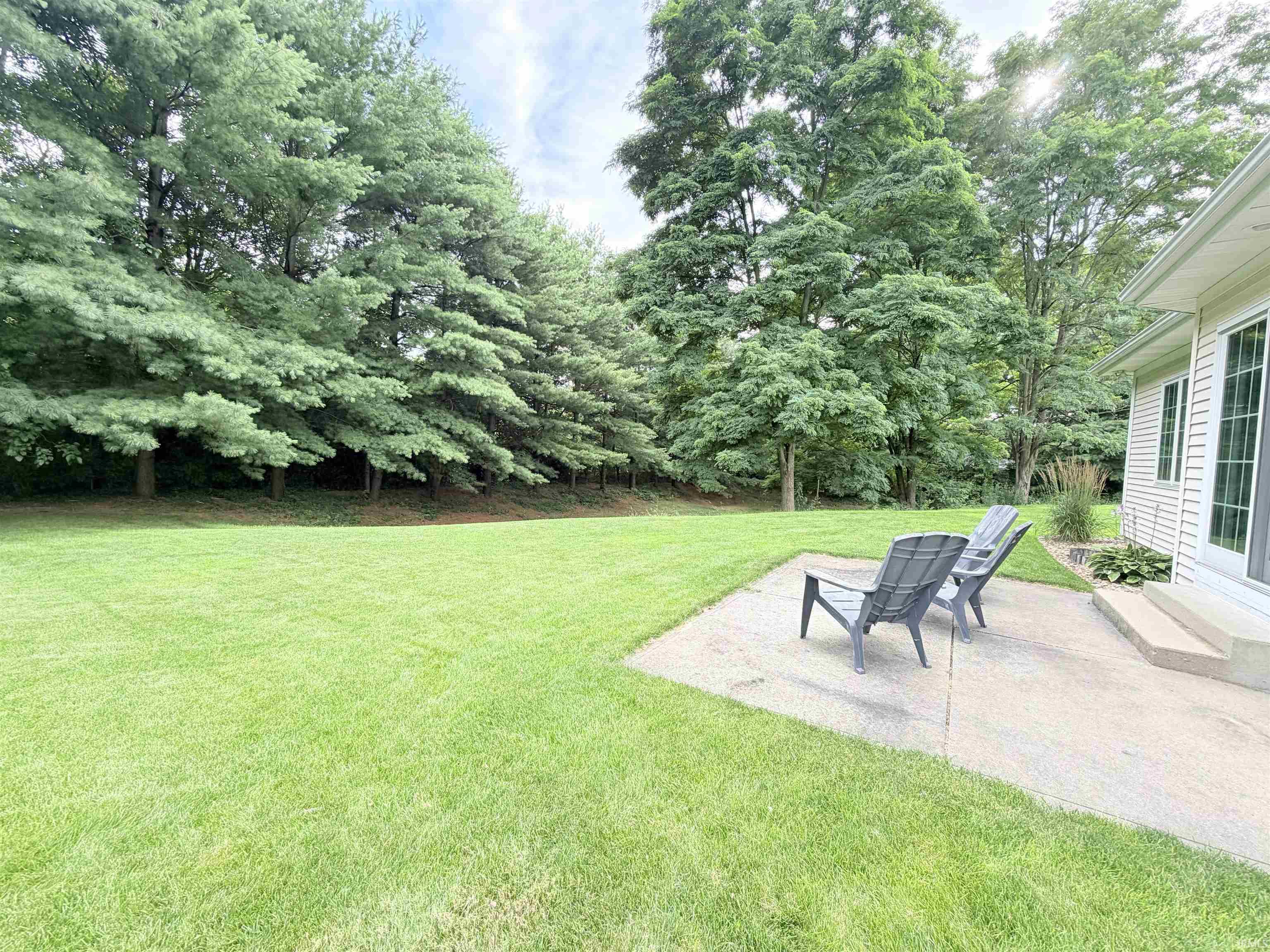 Expansive green lawn fringed by mature trees