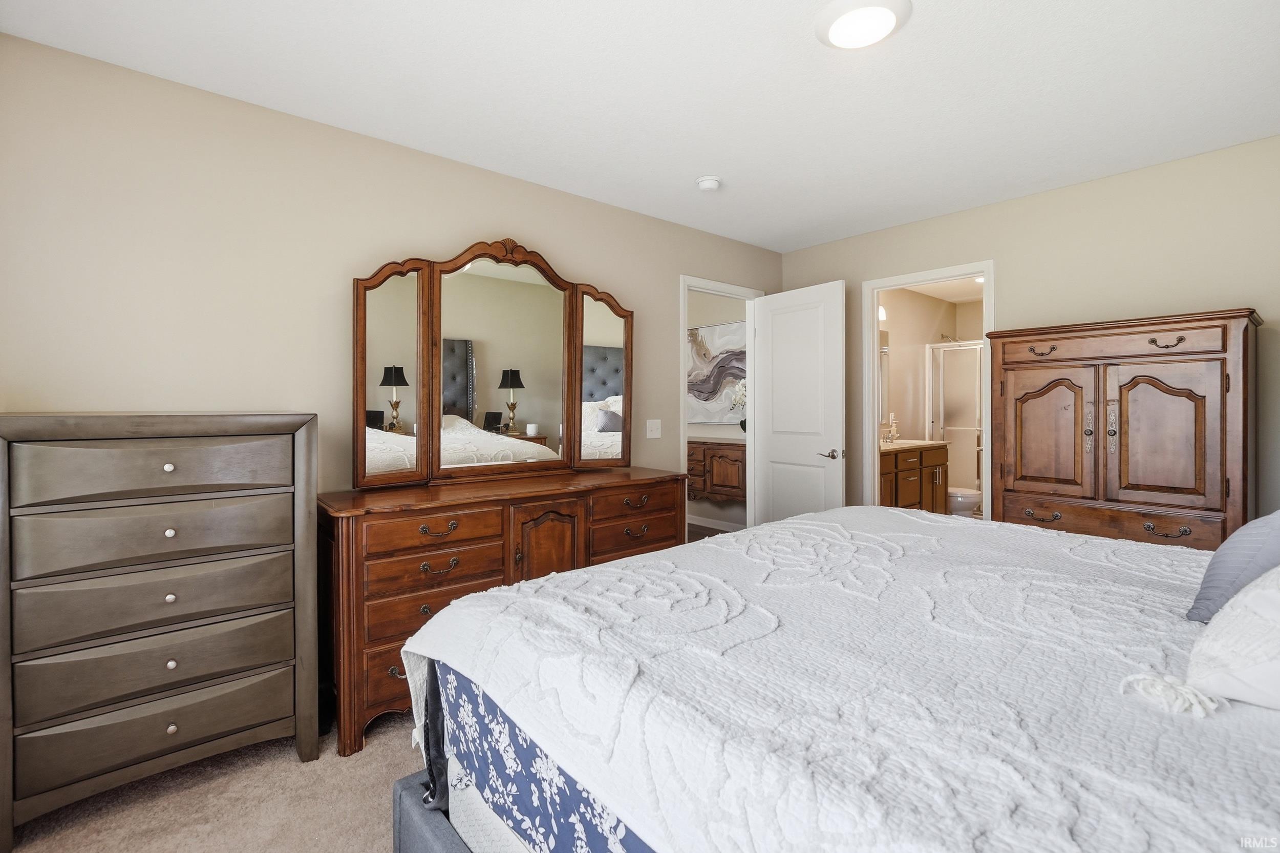 Carpeted bedroom with neutral wall tones and a ceiling-mounted light fixture