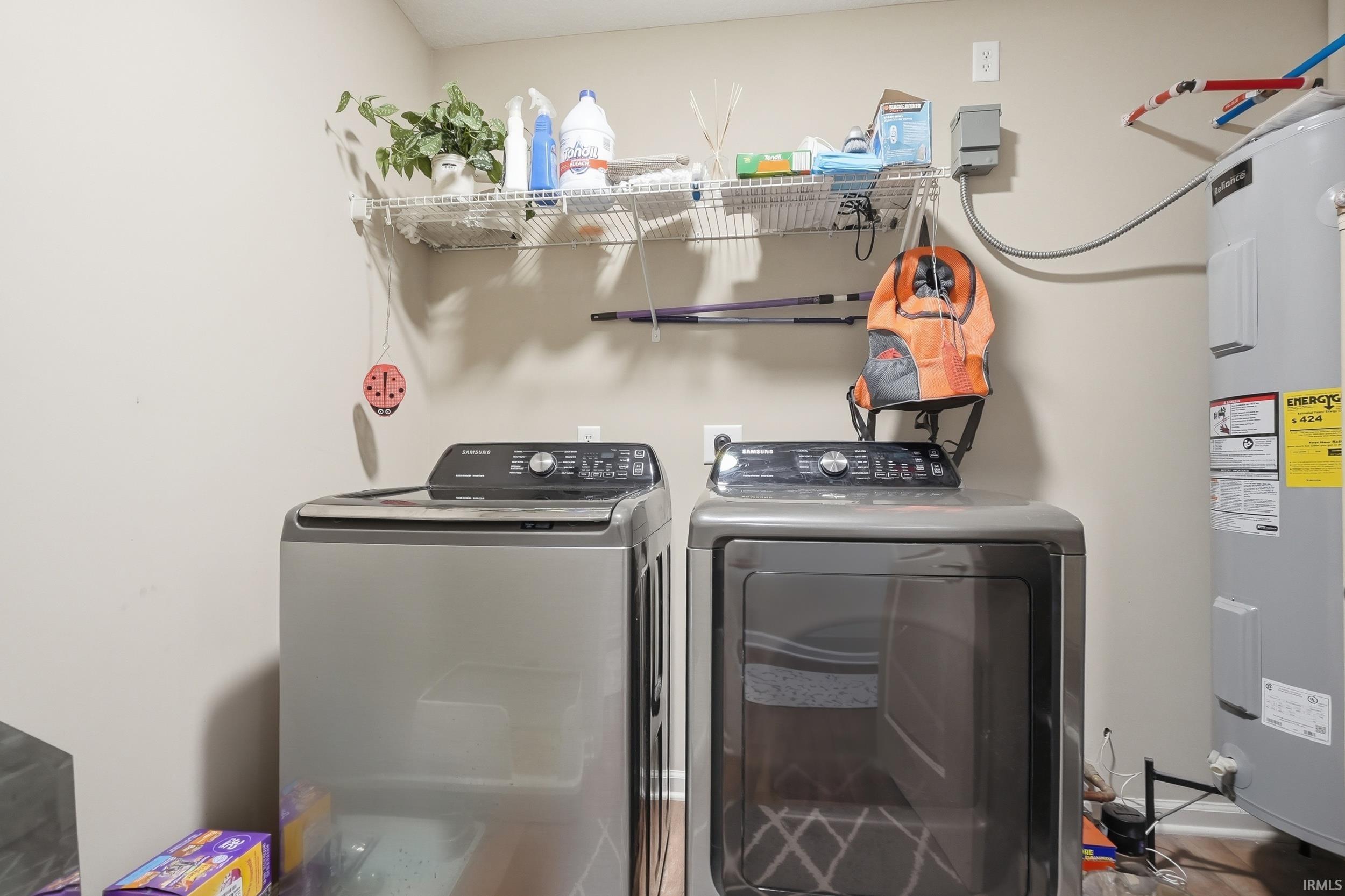 Dedicated laundry area featuring a washer and dryer, an overhead wire shelving unit, and a water heater