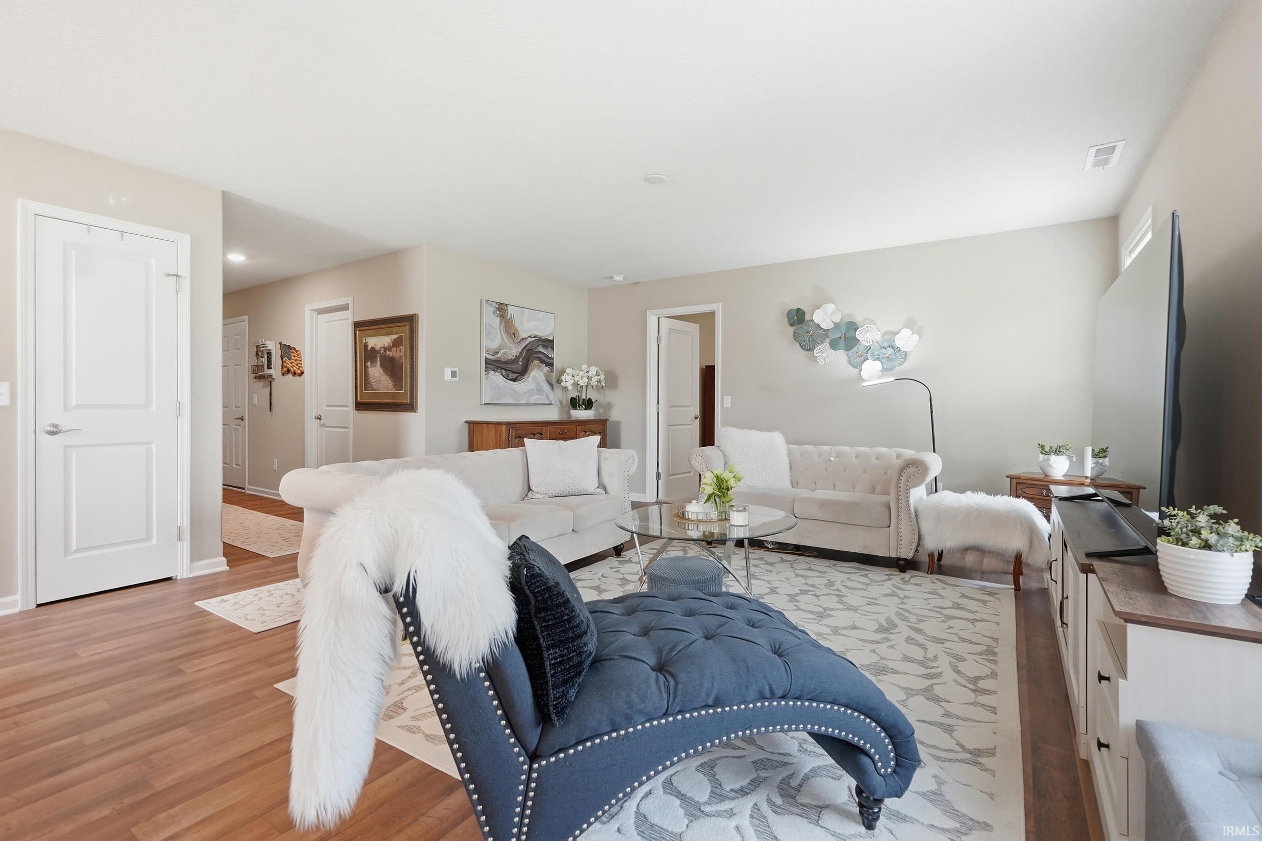 Living area featuring wood-finish flooring, light-toned walls, and white trim throughout