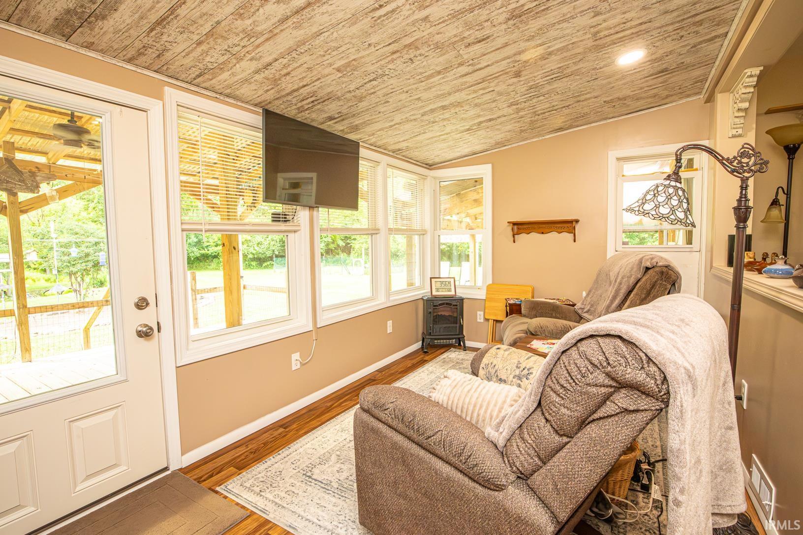 Sunroom featuring wood-finish flooring and multiple windows