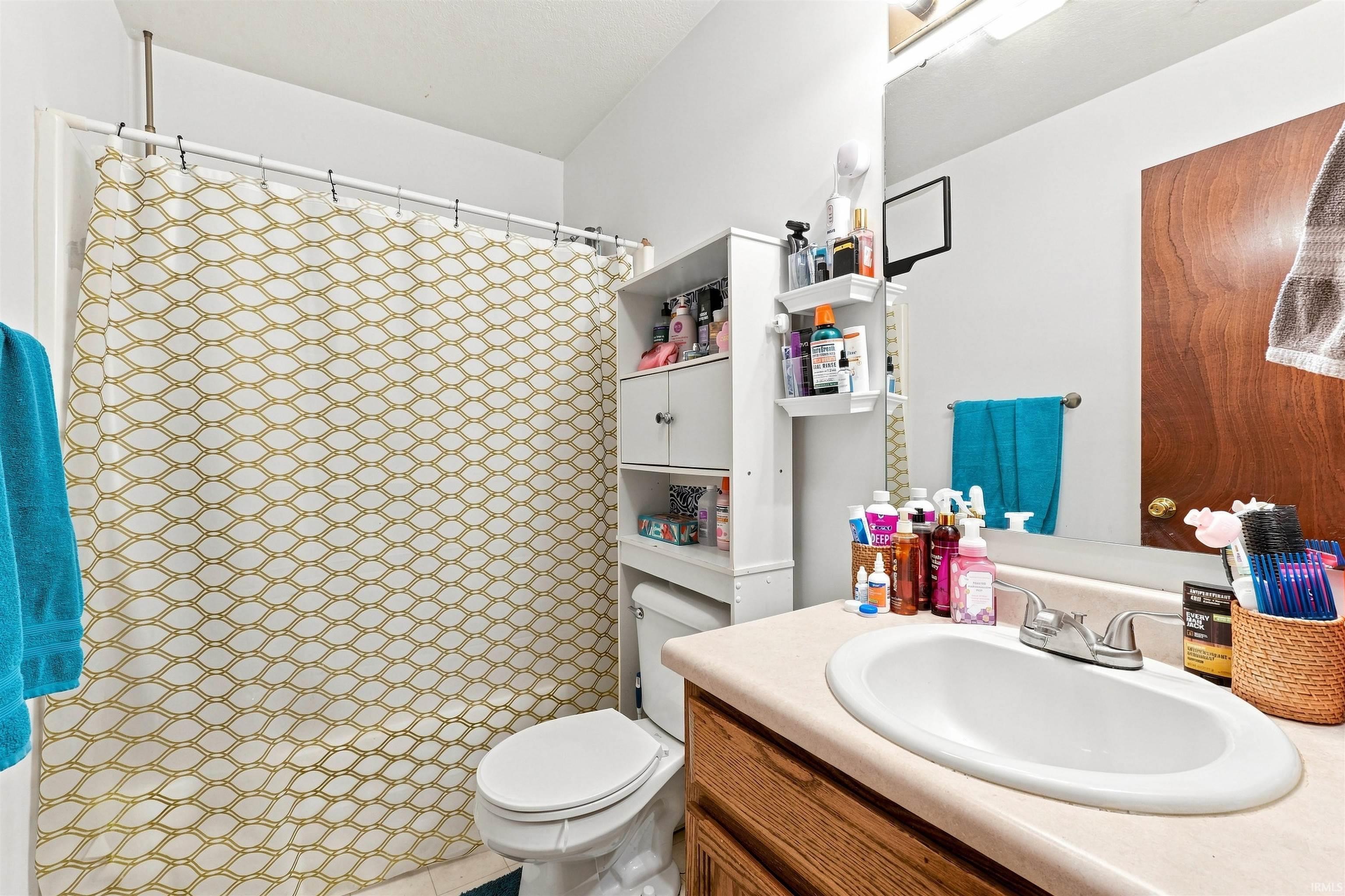 Bathroom featuring a shower/tub combination, white toilet, vanity with an integrated sink, and an overhead lighting fixture