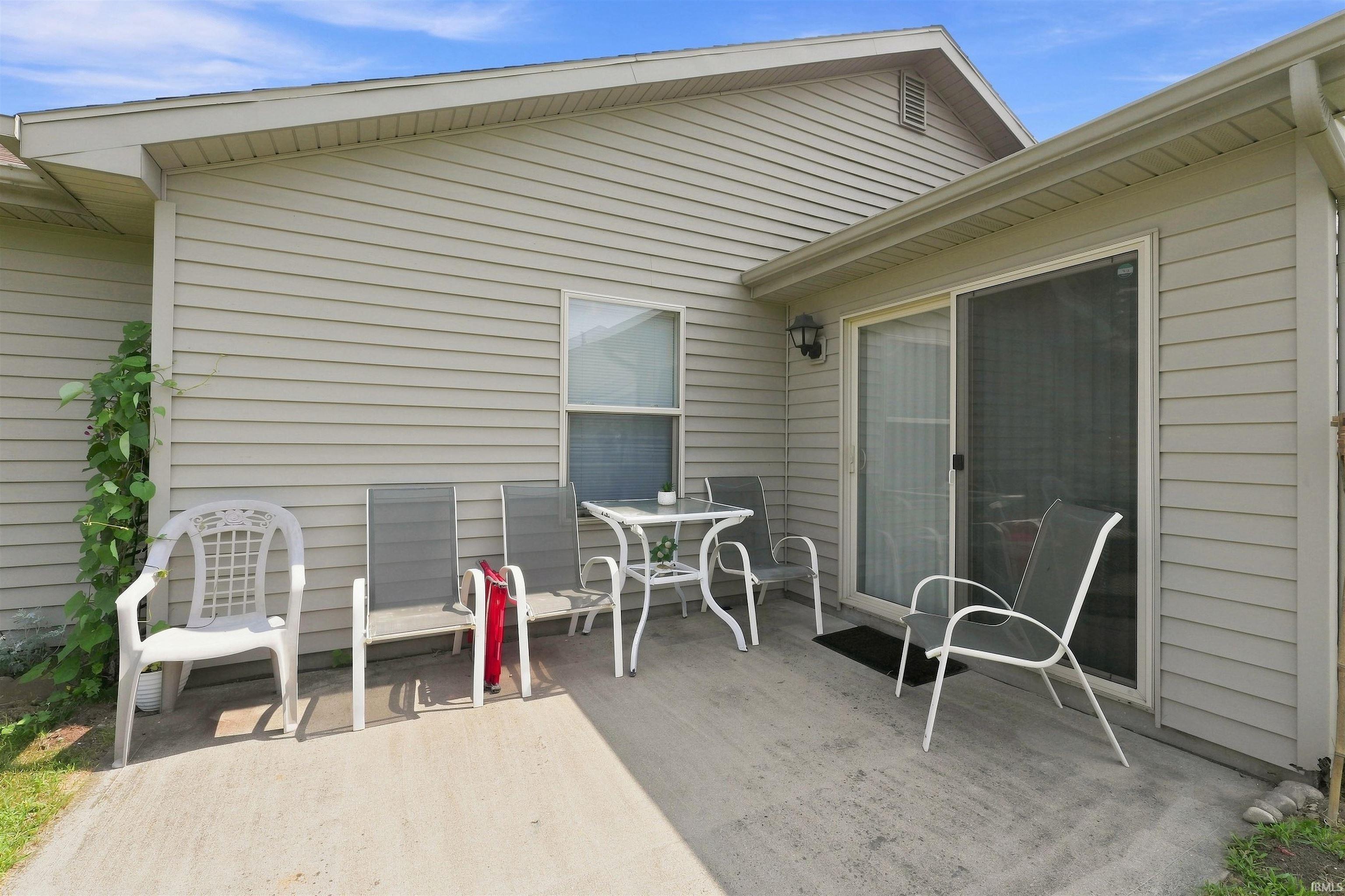 Concrete patio area with direct outdoor access via a sliding glass door