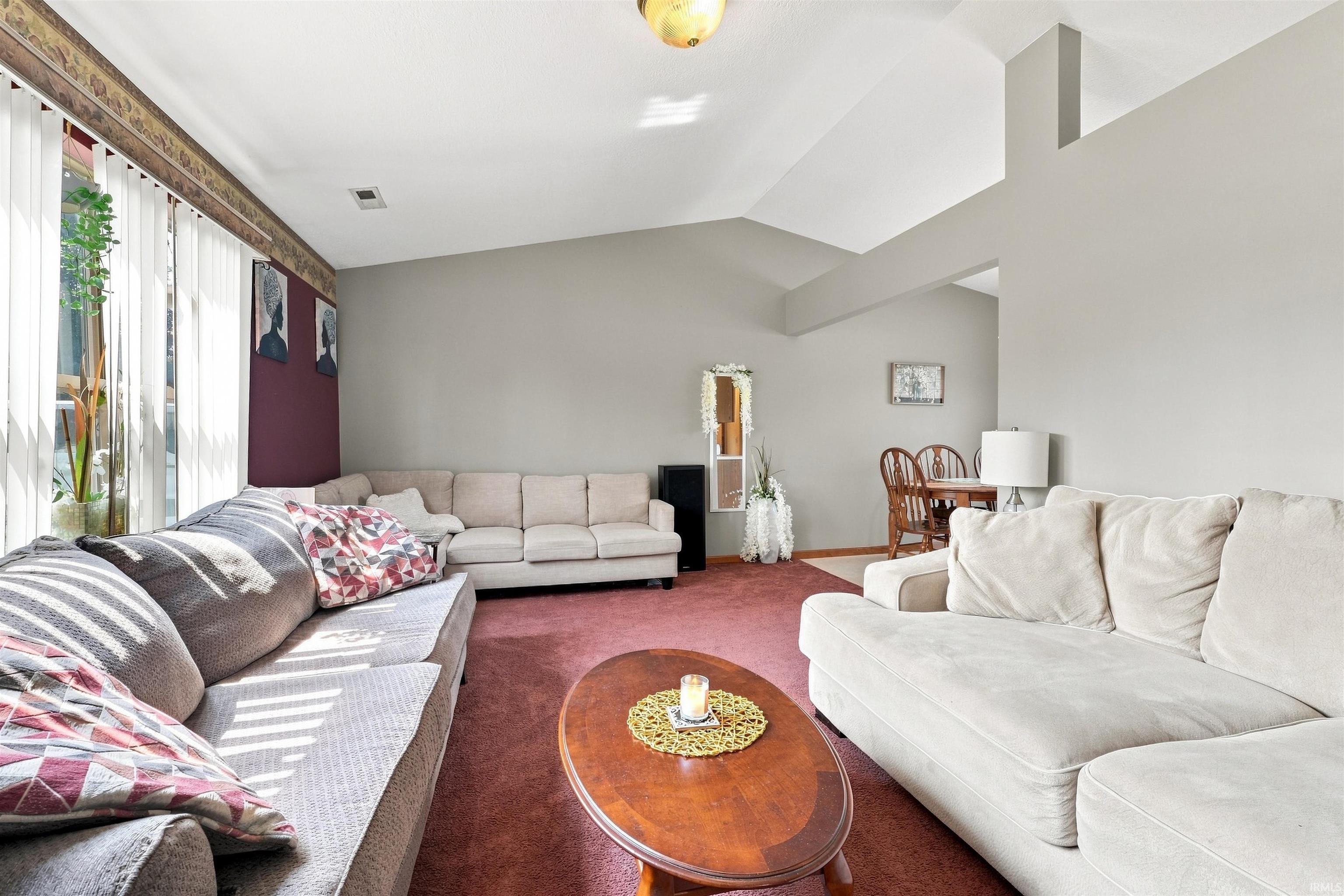 Spacious living area featuring vaulted ceilings and an open concept layout