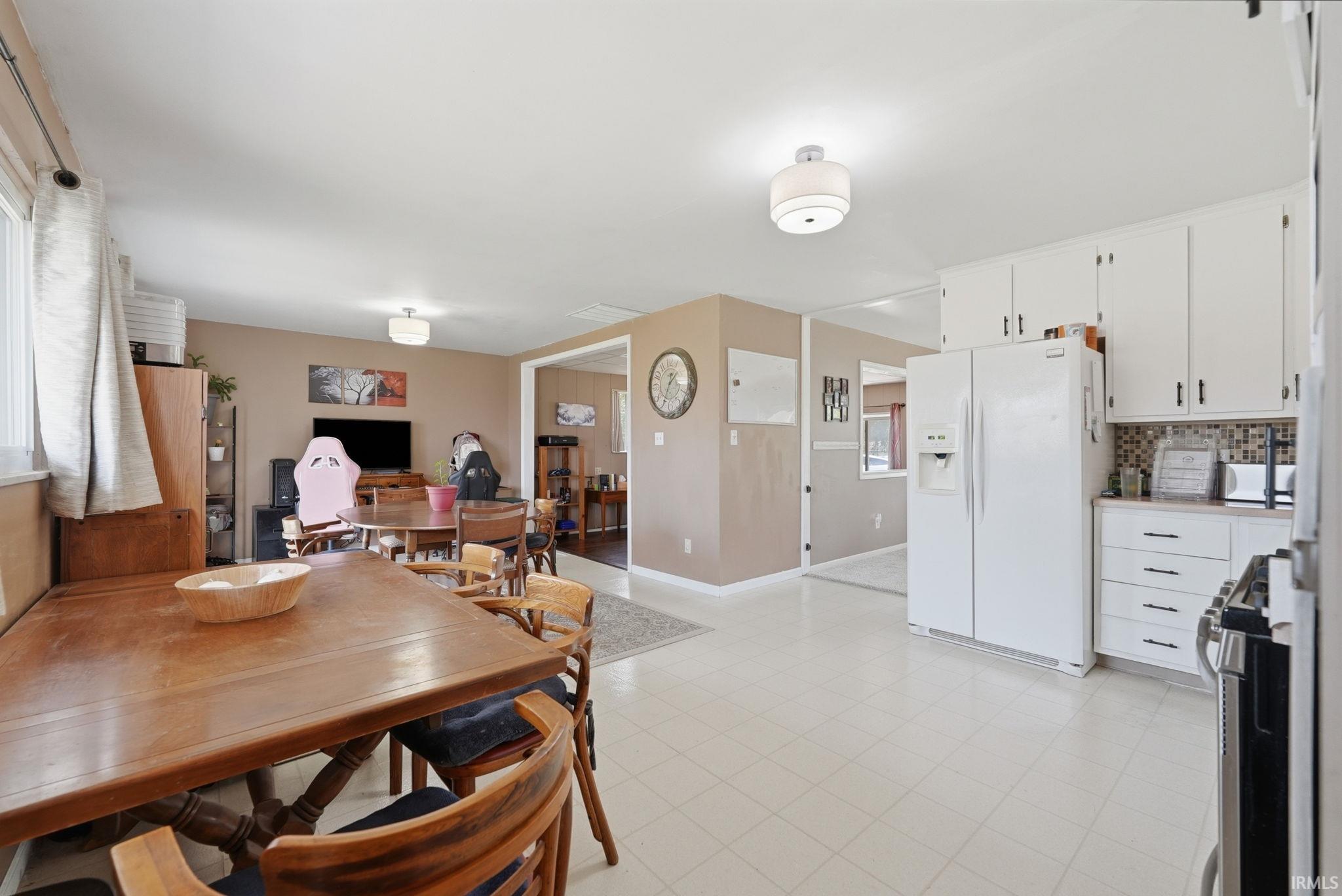 Bright kitchen with white cabinetry and mosaic tile backsplash