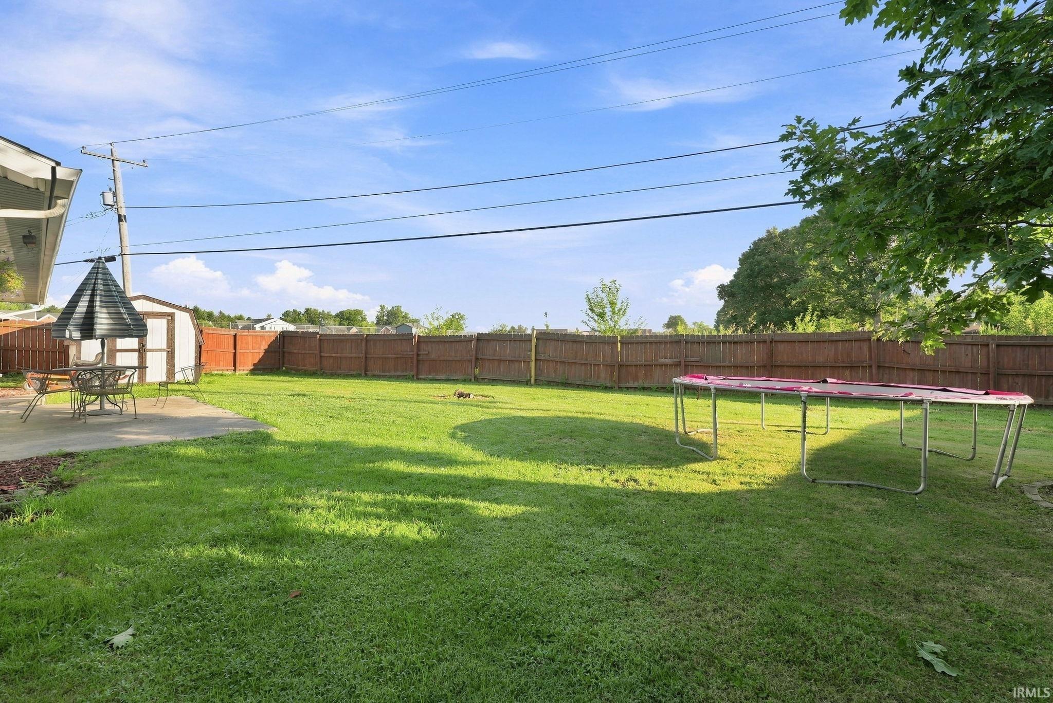 Expansive green lawn with a full privacy fence