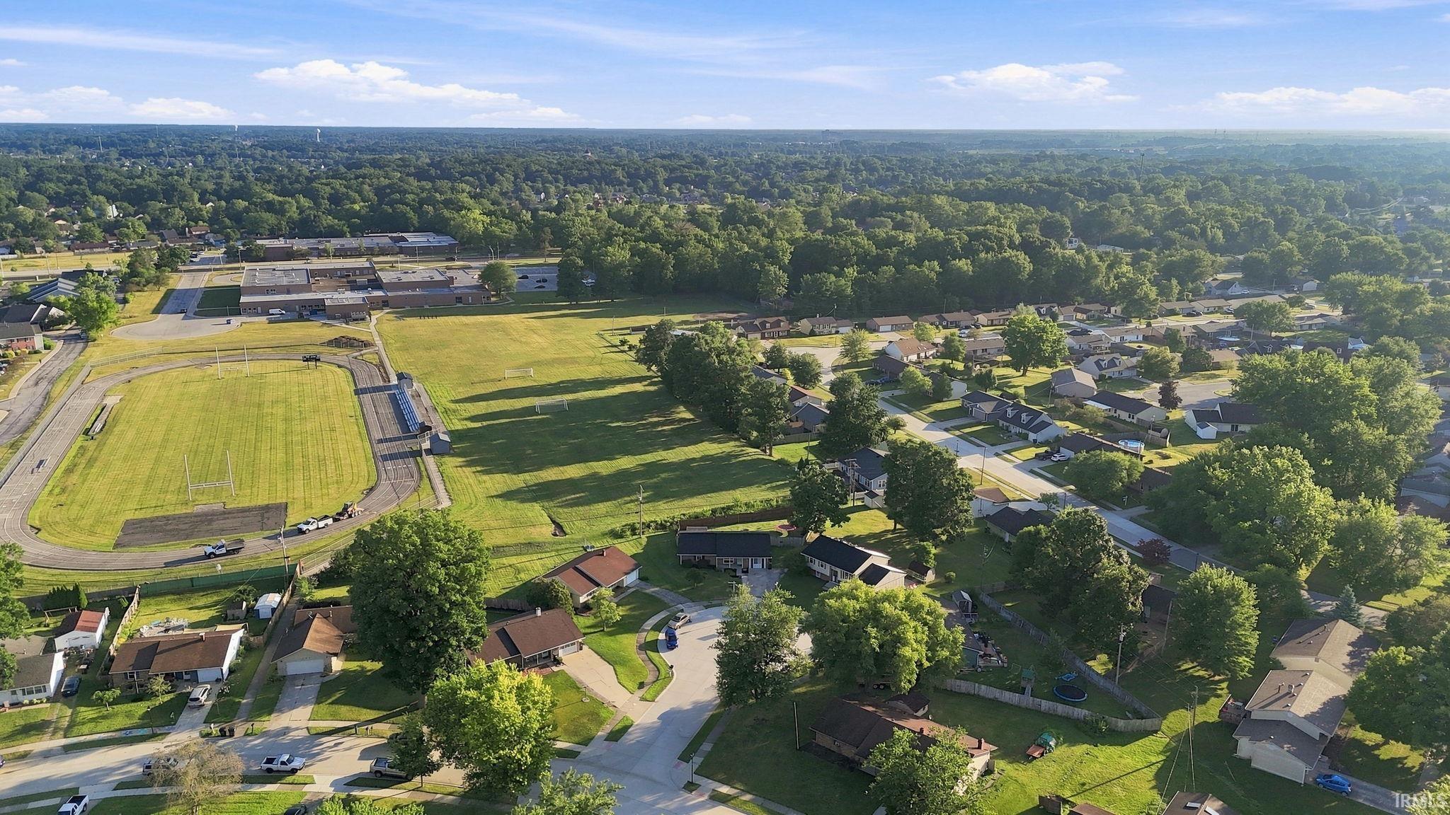 Aerial perspective showcasing a residential area with varied housing styles and mature tree coverage