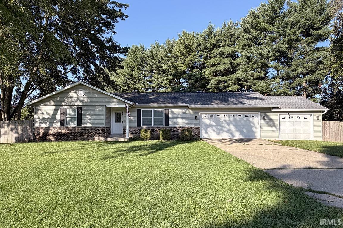 Ranch-style residence featuring light-colored siding, a brick accent facade, and a shingled roof