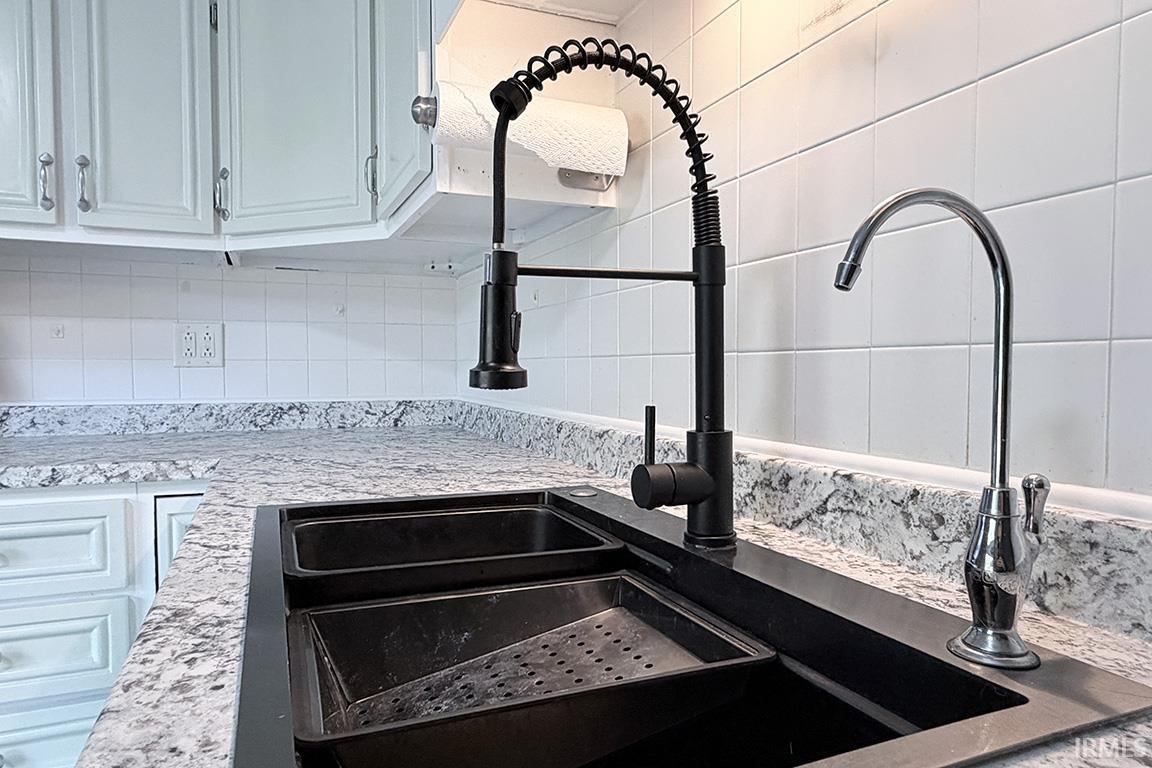 Dual-basin black sink featuring a matte black pull-down faucet and a separate chrome water dispenser