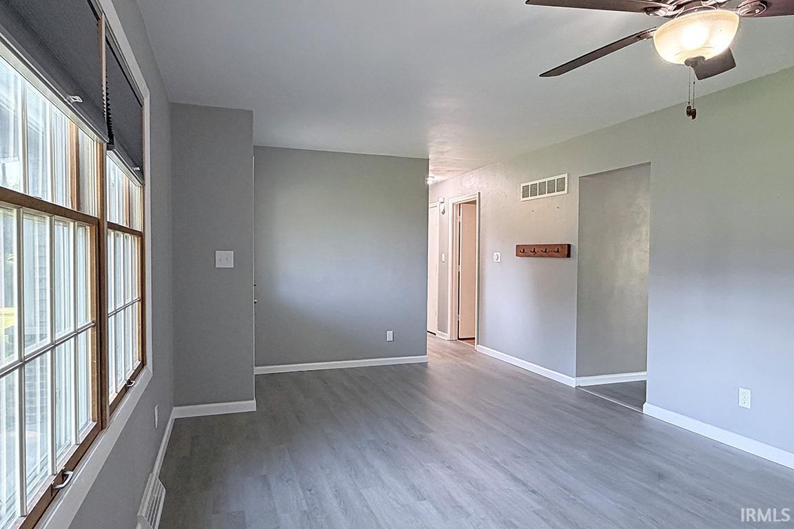 Spacious interior featuring wood-finish flooring, light gray wall tones, and white baseboards