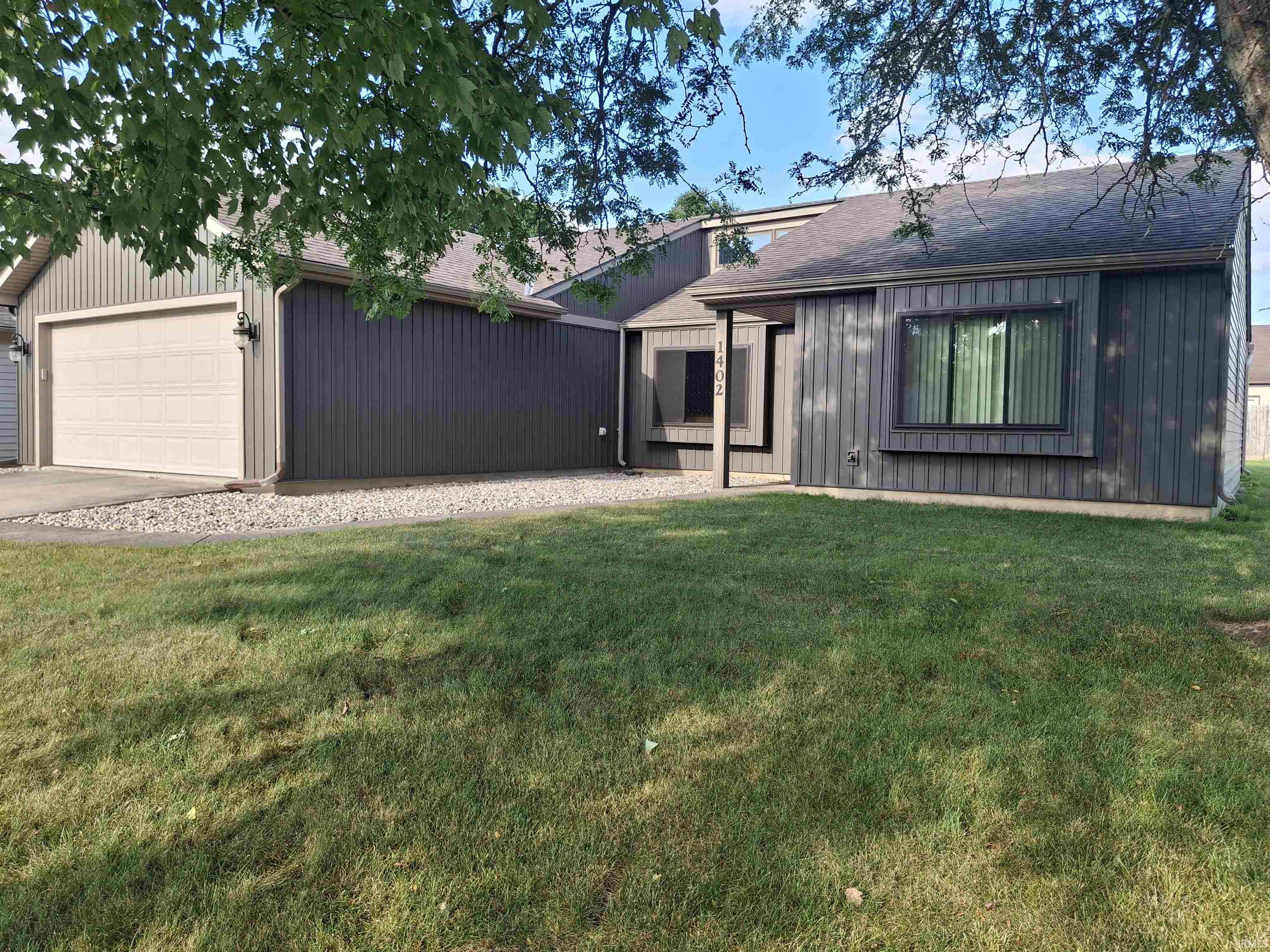 Contemporary-style residence featuring vertical siding and a dark roofline