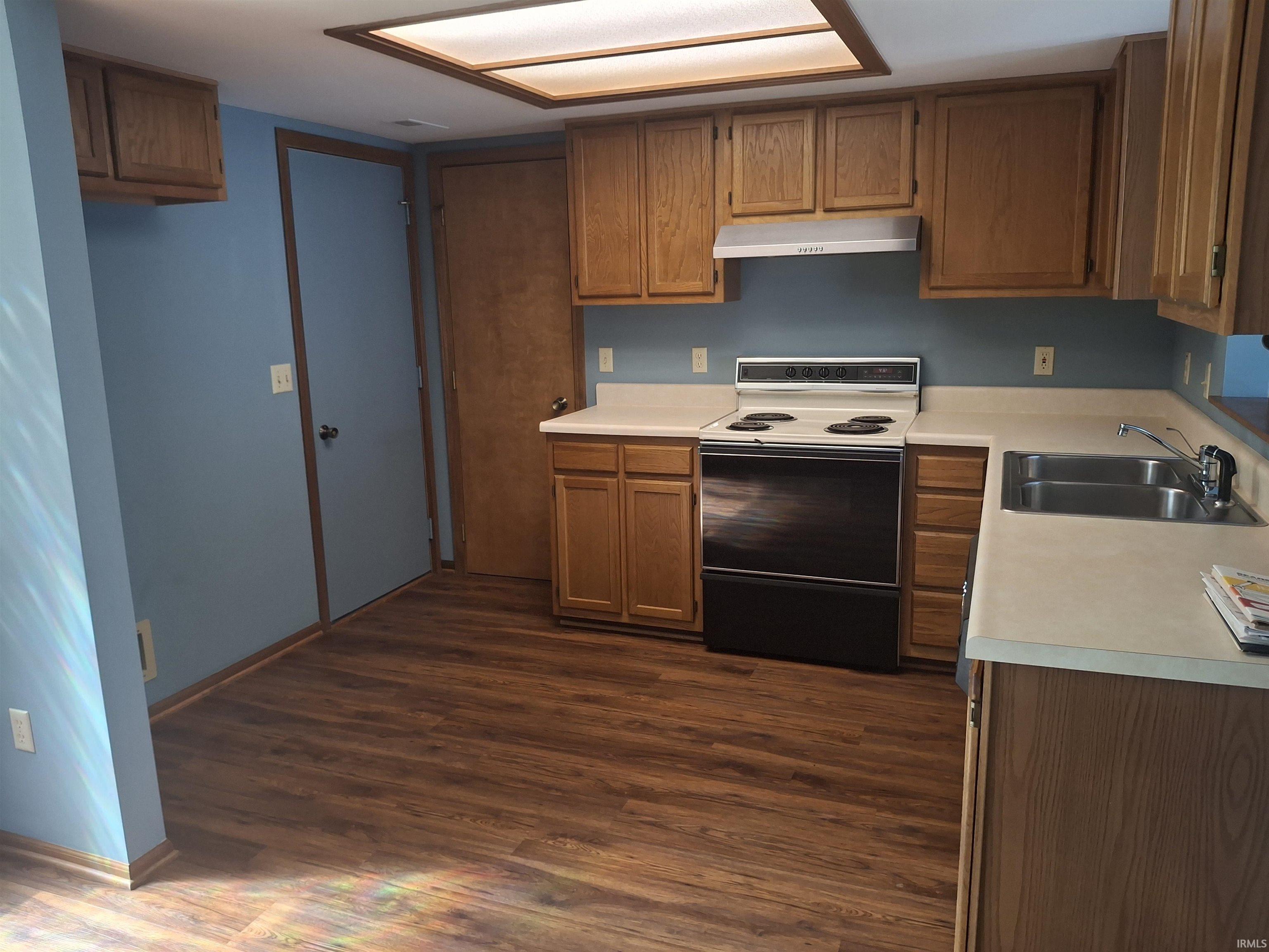 Spacious kitchen featuring wood cabinetry, laminate countertops, and stainless steel electric range