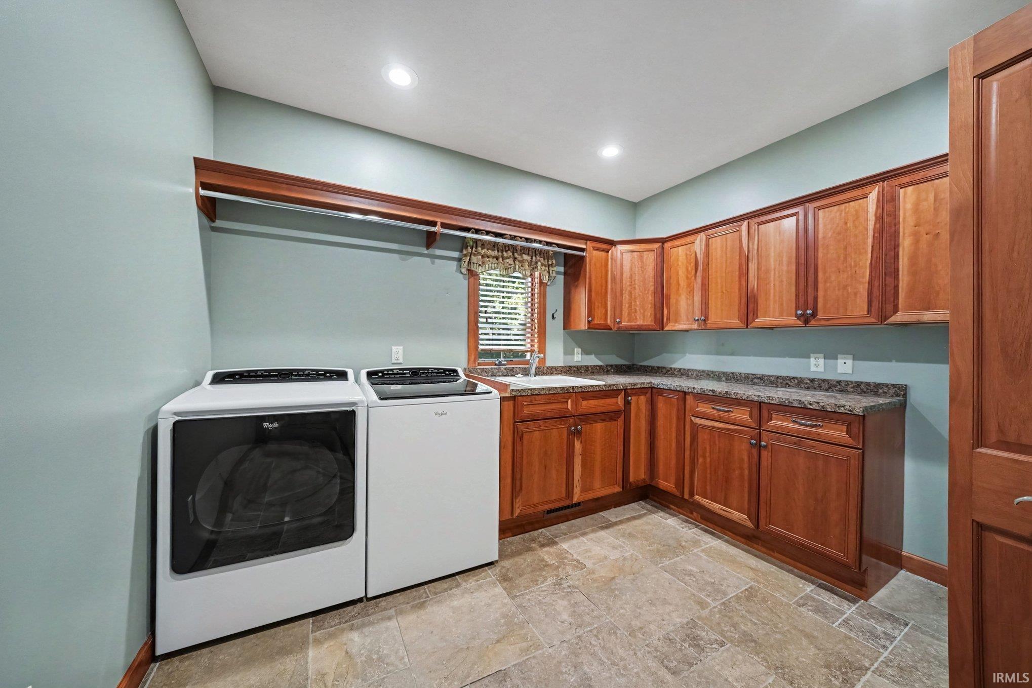 Utility room featuring extensive wood cabinetry, L-shaped countertop, recessed lighting, and tile flooring