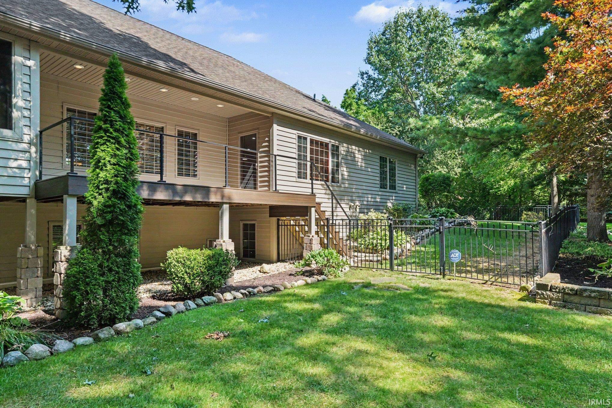 Two-story exterior with a covered upper deck featuring cable railings and recessed lighting