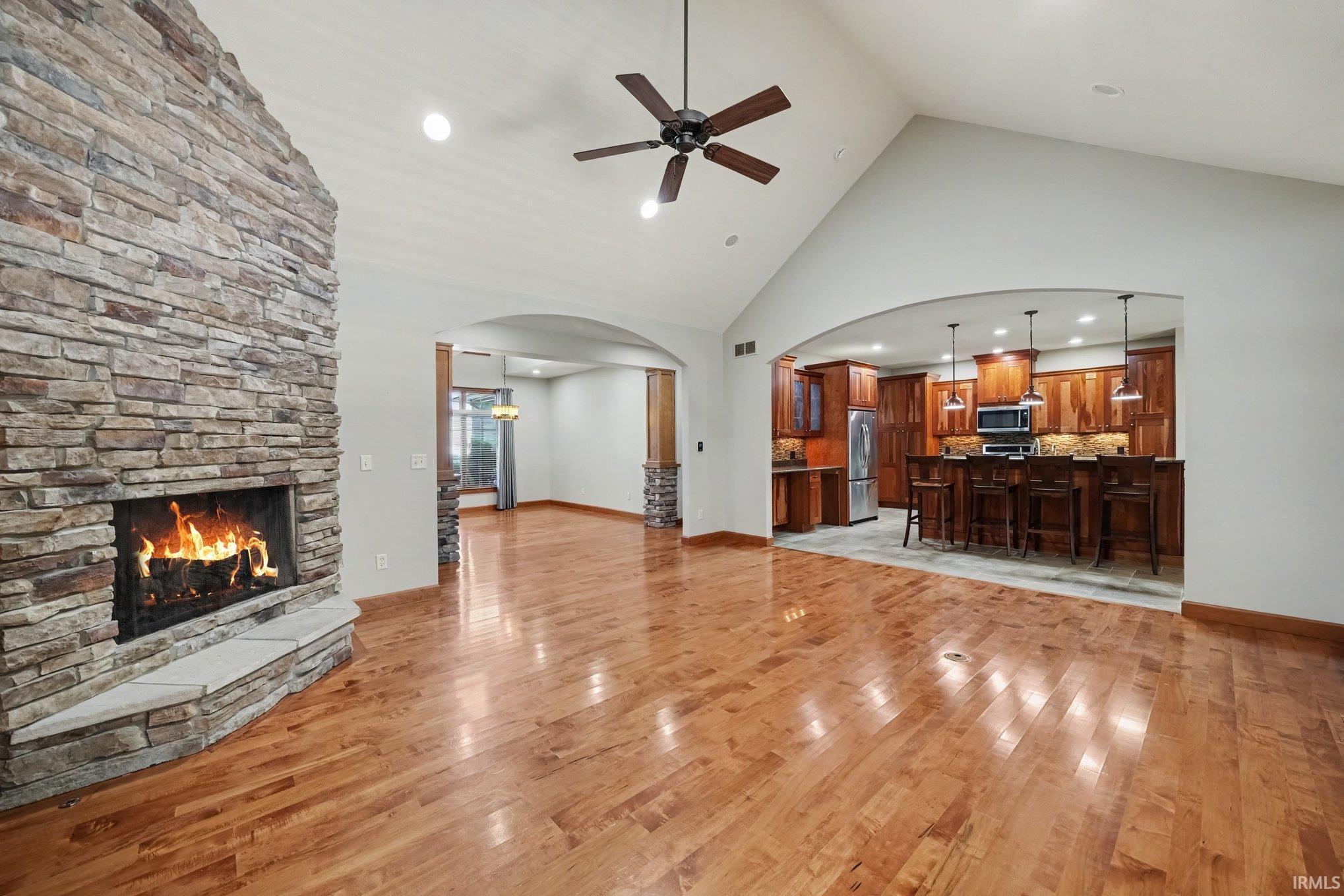 Spacious great room featuring soaring vaulted ceilings, ceiling fan open to the Kitchen